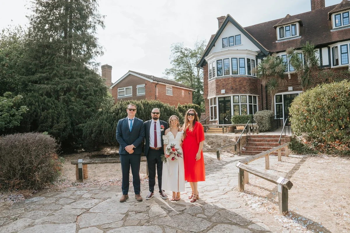 Weybridge Register Office wedding photography of the newlyweds with friends in the gardens outside the Surrey wedding venue.