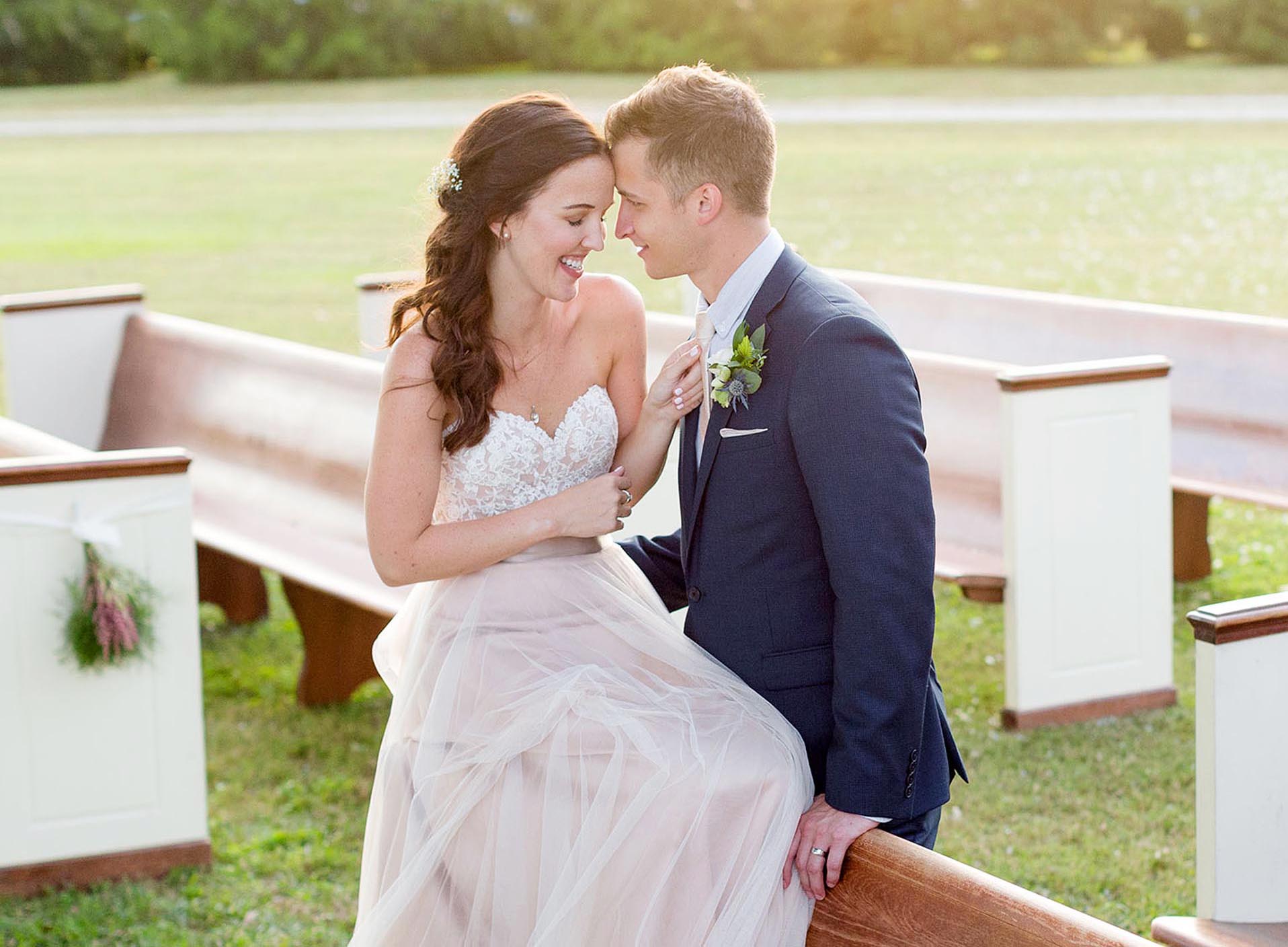 Bride and groom smiling at their wedding ceremony site.