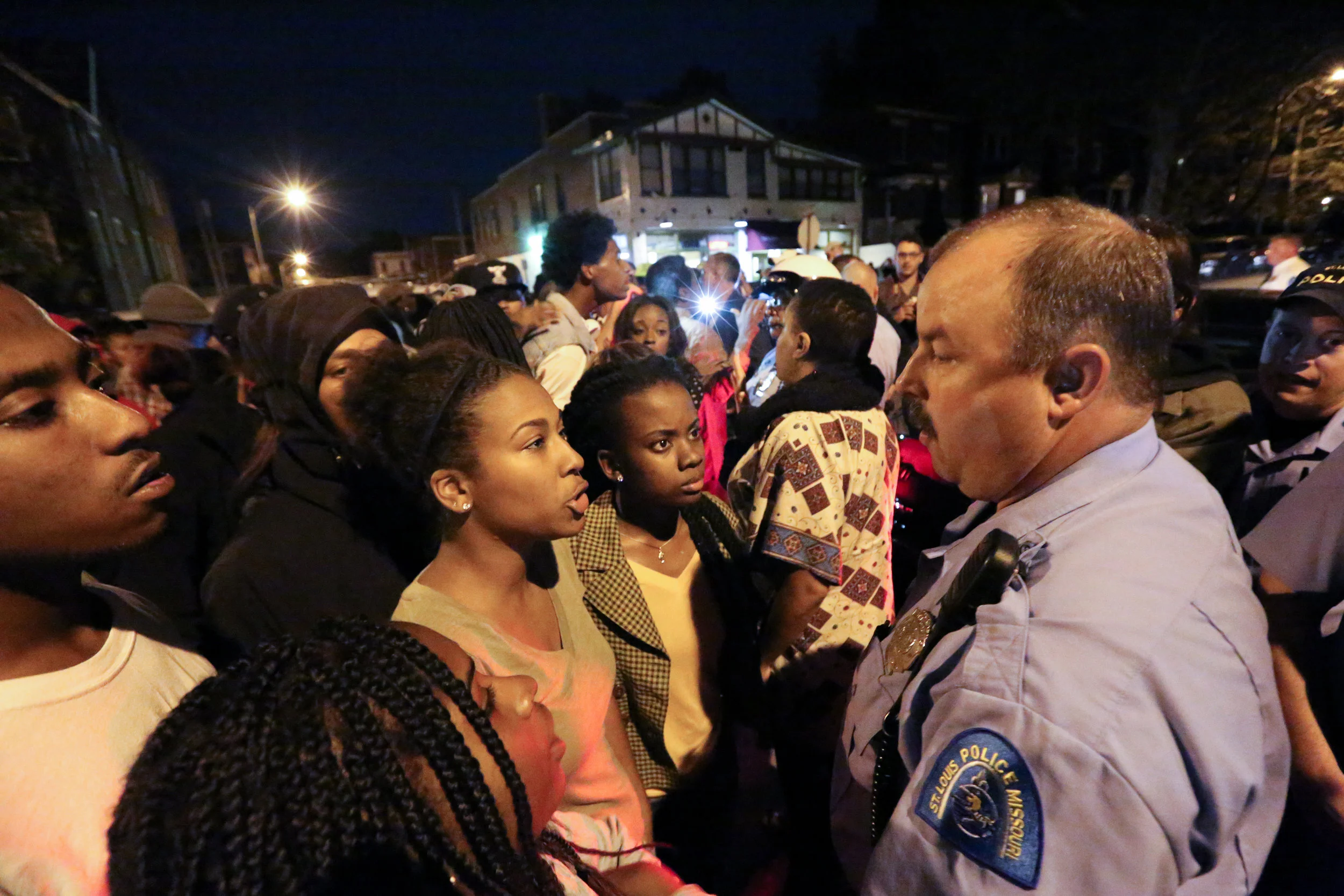 Alexis (left) and Brittany confront a police officer as the vigil for Vonderrit Myers Jr. is interrupted with an order to disperse. 