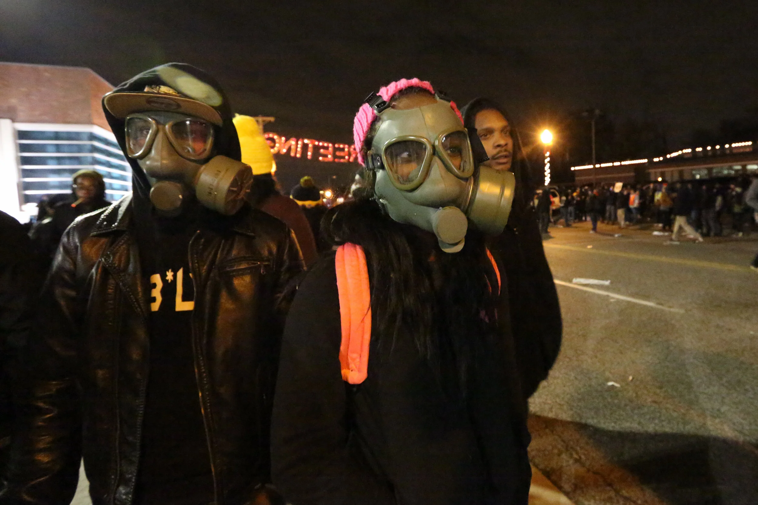 Having come prepared for the worst, T-Dub (left) and Rika practice putting on their gas masks in front of the Ferguson police department, waiting for the Grand Jury announcement in the case against officer Darren Wilson for the killing of Mike Brown.
