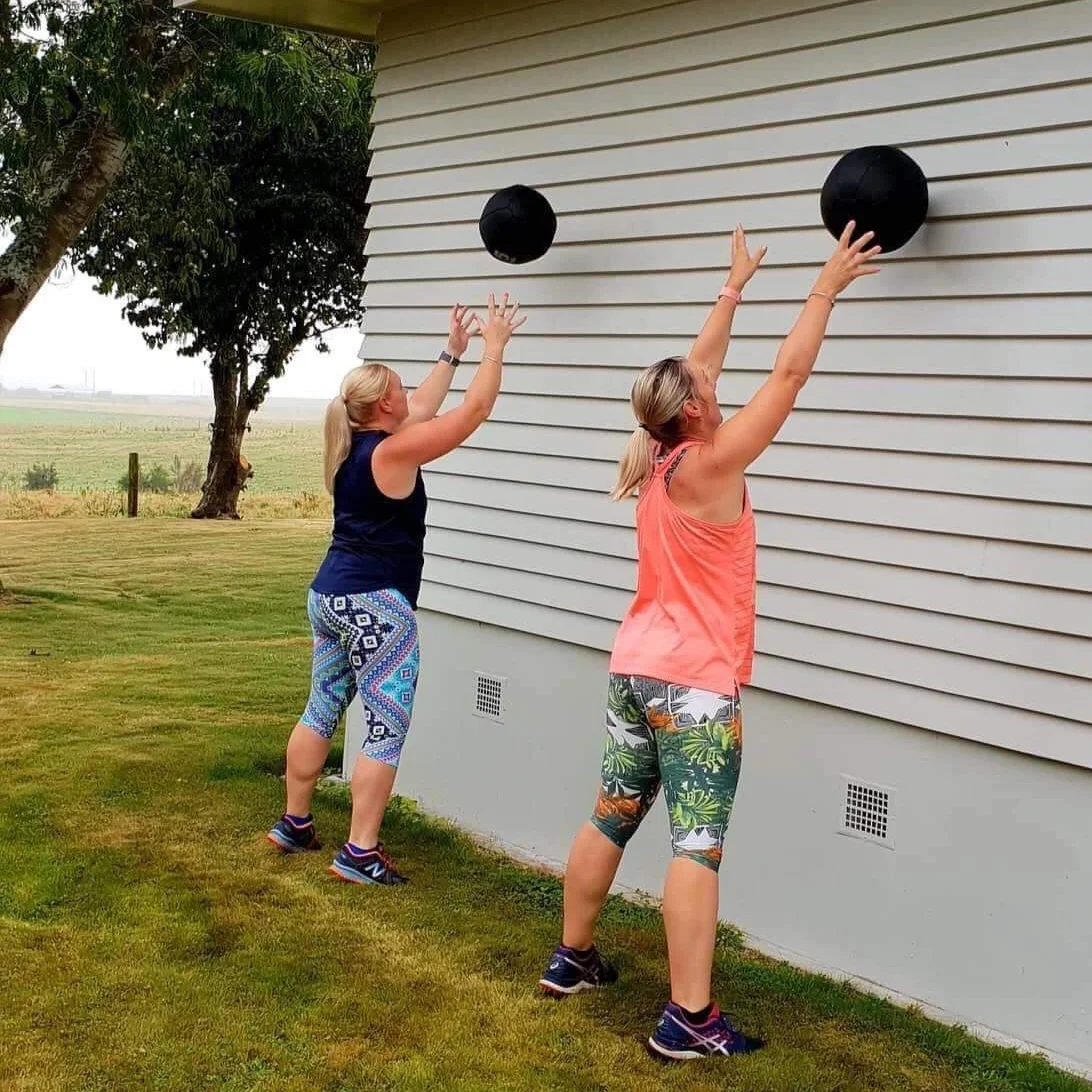 ladies throwing balls up against wall.jpg