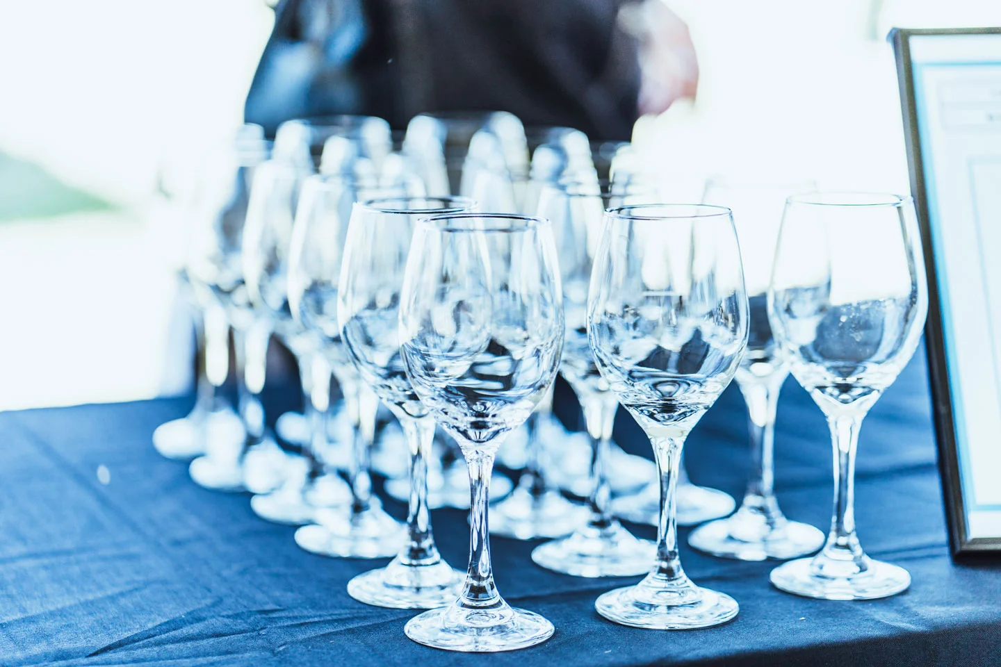 Multiple empty wine glasses on a dark table with a blurred background.