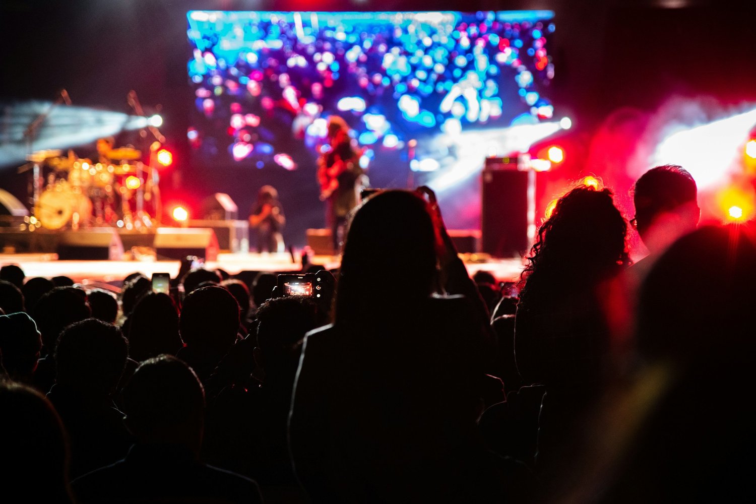 Concert audience facing an illuminated live music stage