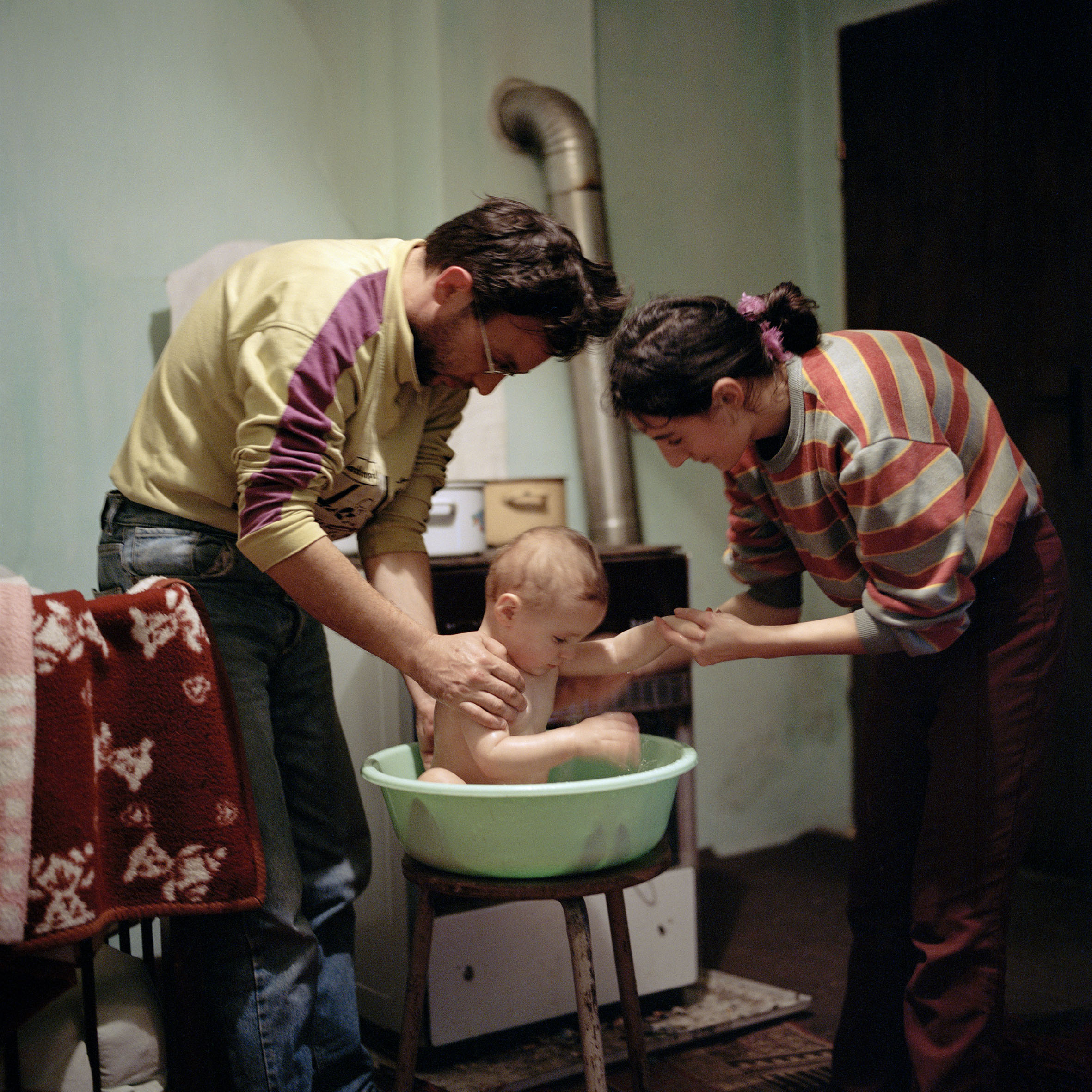  Nebojsa and Slavica Eremic wash baby son Nikola in their newly rebuilt home. Although they failed to receive building aid from the state, ADRA (a German NGO) donated building materials and Nebojsa did the work himself. Jurga, Croatia. 