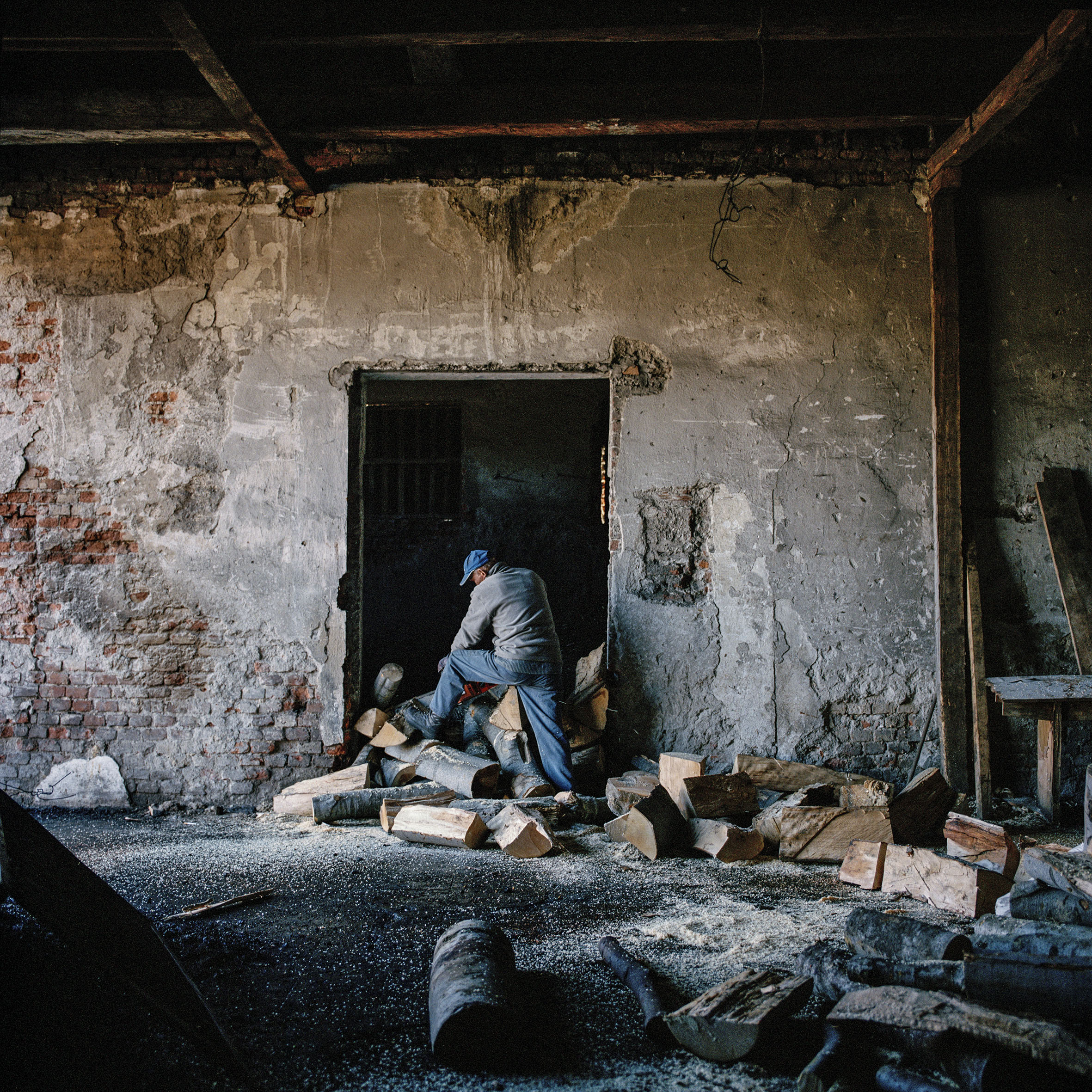  Mirko Gvoic cuts firewood for the boiler that heats the rooms at Rtanj refugee centre. Rtanj, Serbia. 