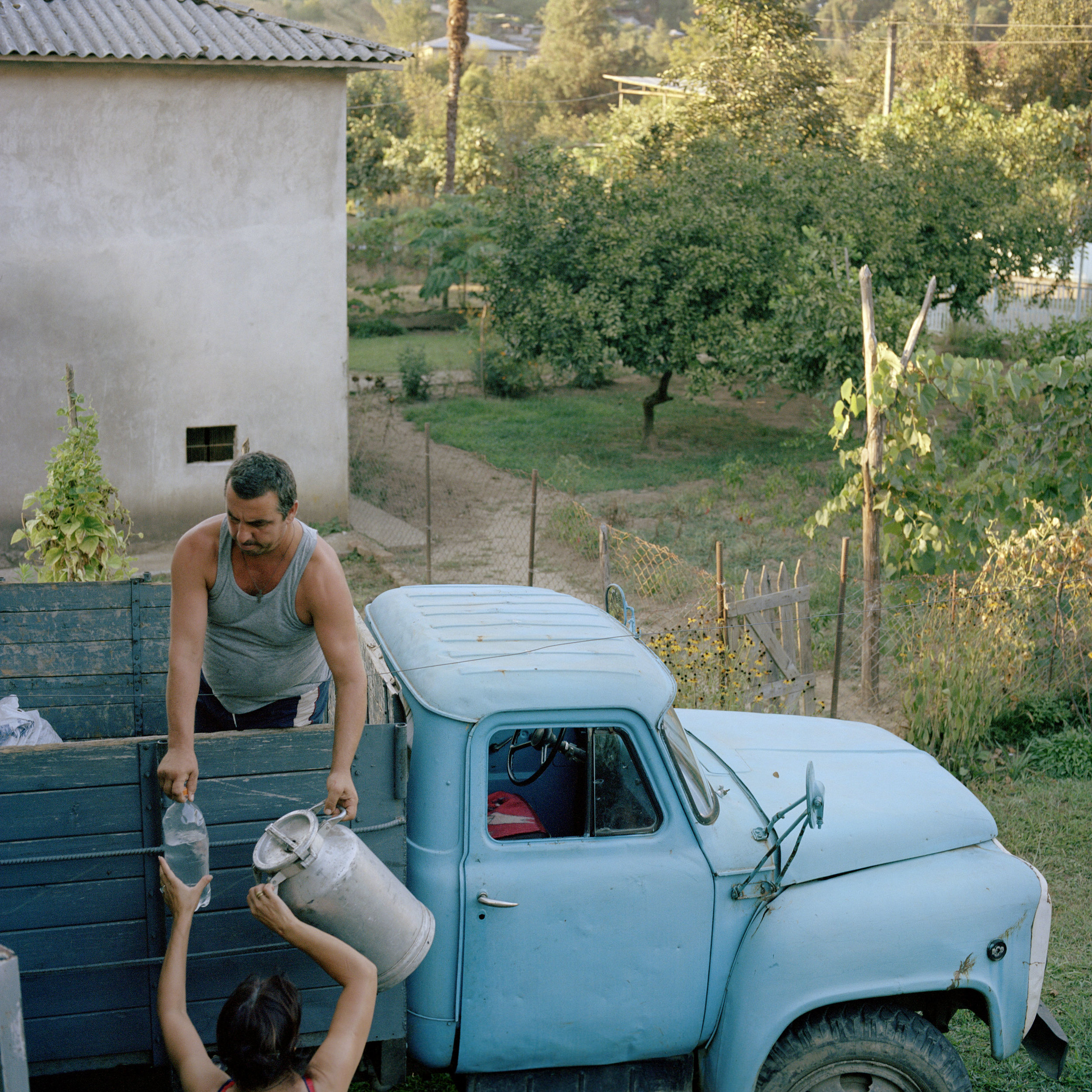 Mirab Lejava is helped by his wife after a long day collecting hazelnuts from his land in the mountains nearby.