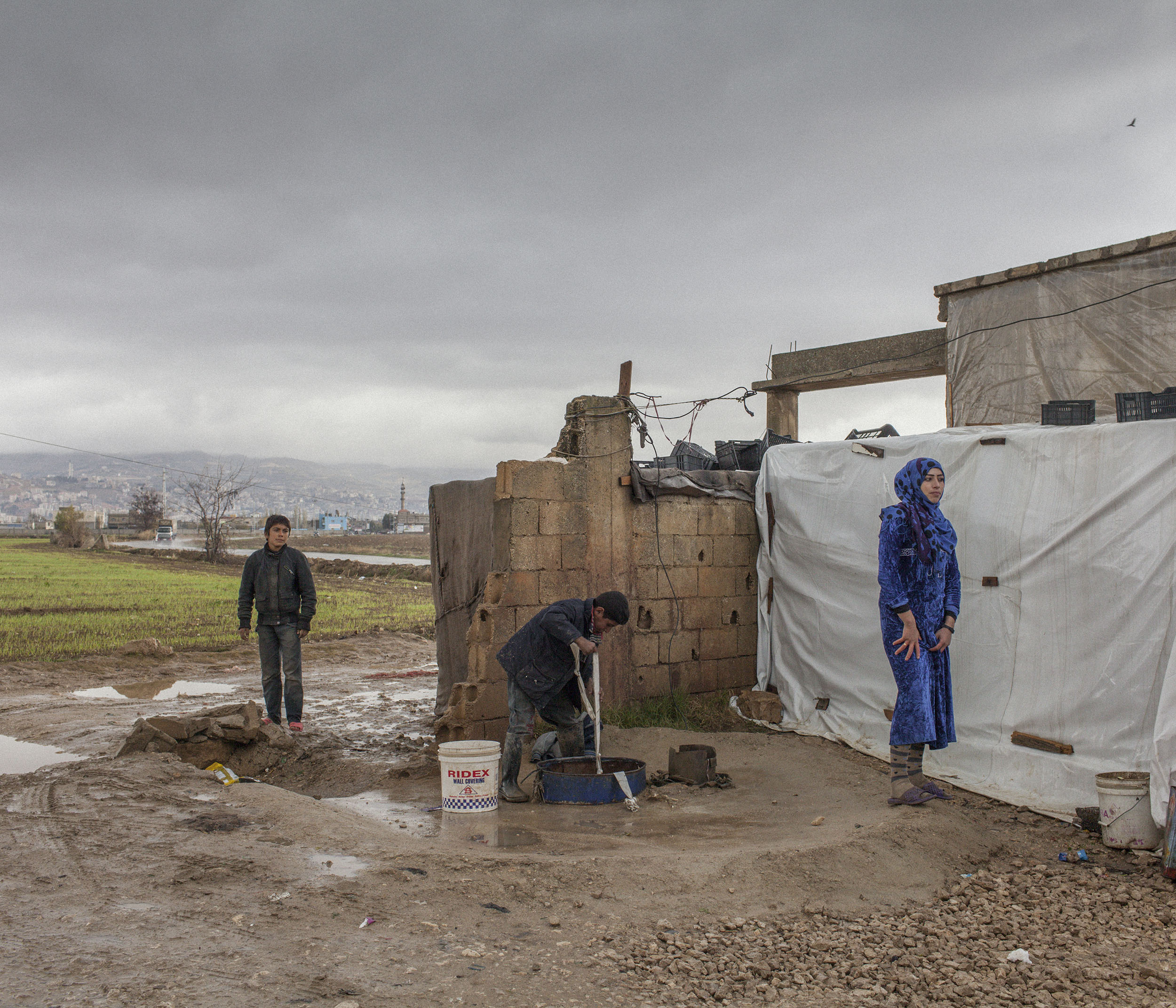  Syrian refugees collect water at a tented settlement in Lebanon’s Bekaa valley. 