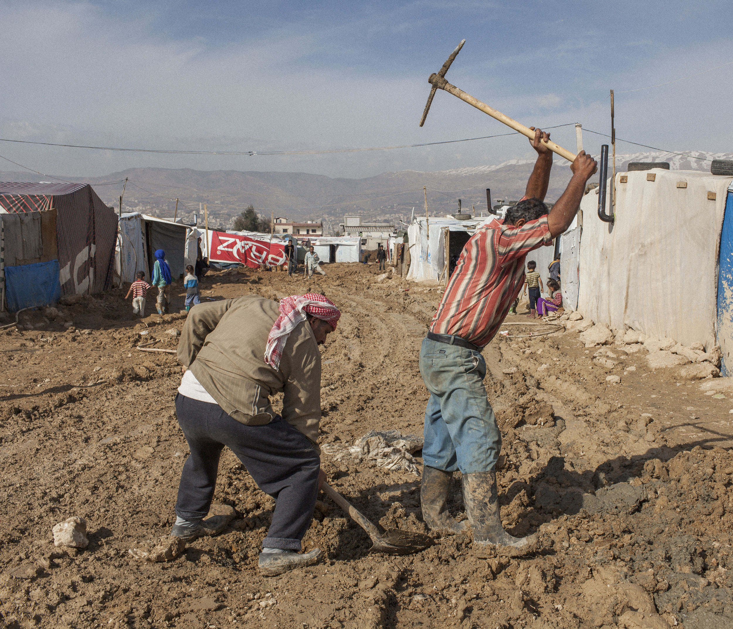  Syrian refugees dig a drain beside their tent at Dalhamieh informal settlement in Lebanon's Bekaa valley. 