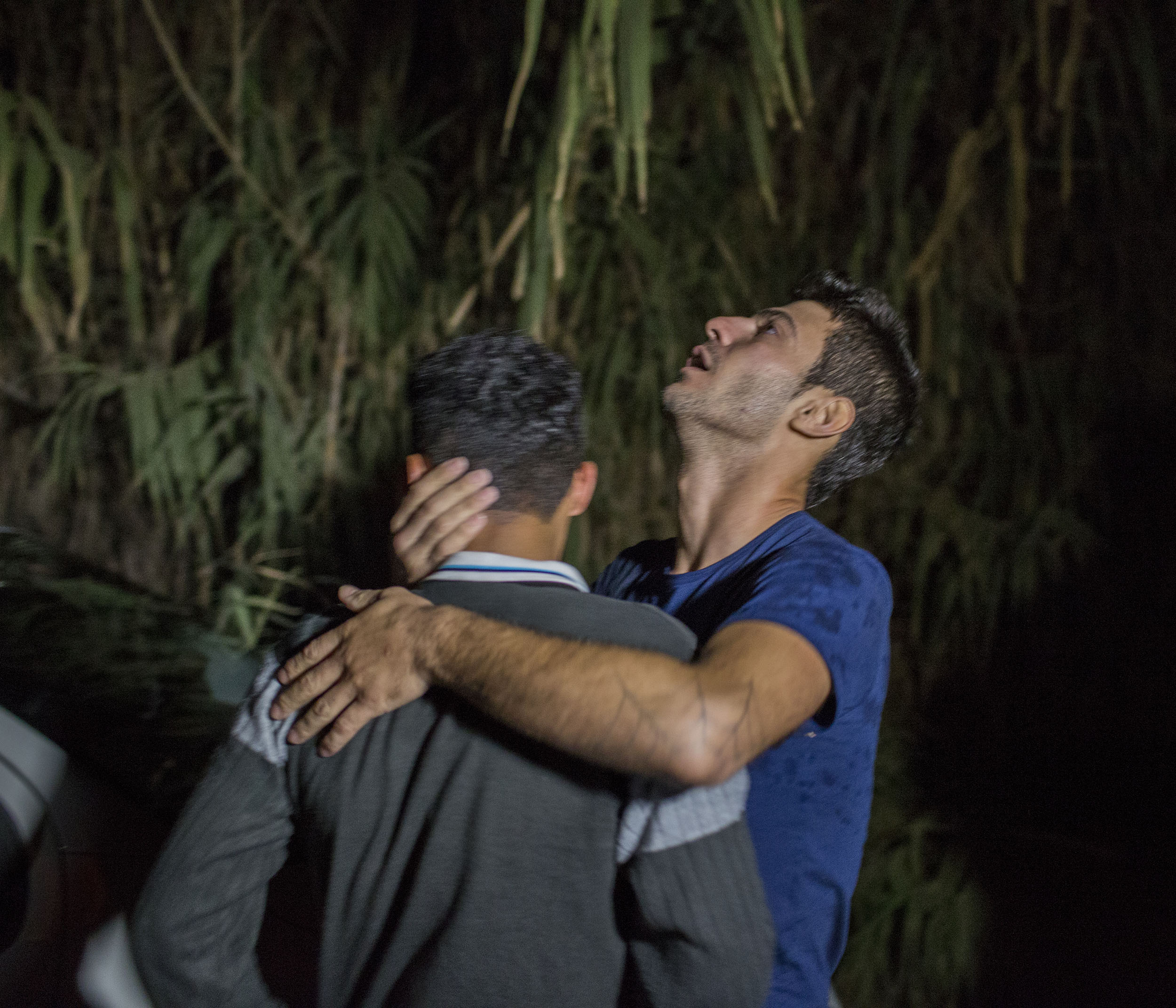 Two young men from Syria embrace each other and cry tears of relief after reaching the Greek island of Lesbos late at night after crossing the Mytilini straits from Turkey in a inflatable boat.
