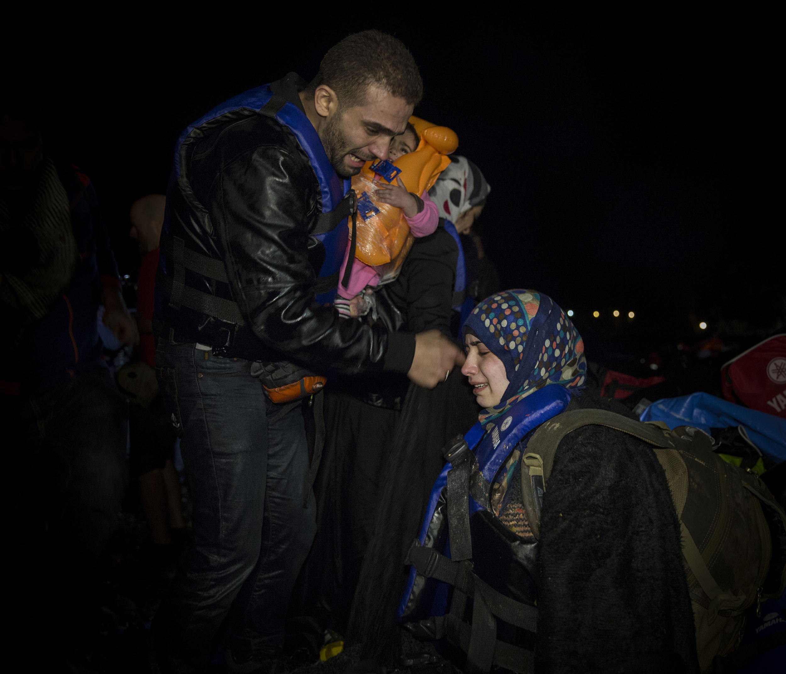 A Syrian man comforted his wife after they arrived on the Greek island of Lesbos having crossed the Aegean sea from the Turkey at night.