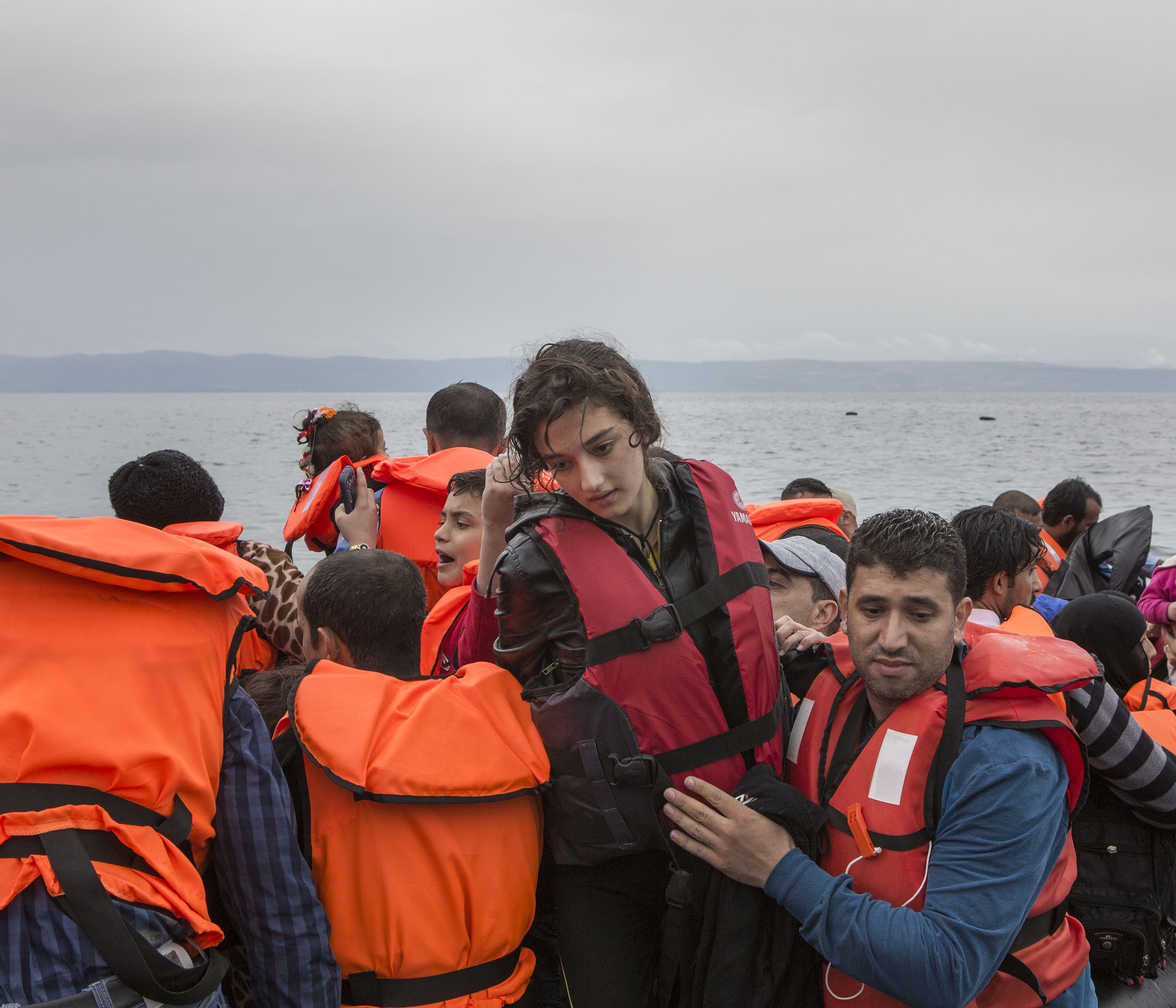 16-Year-old Syrian refugee Shahed is helped out the boat she crossed from Turkey to Lesbos in by a fellow passenger. She fled her home in Syria along with her parents and brother 10 days before.