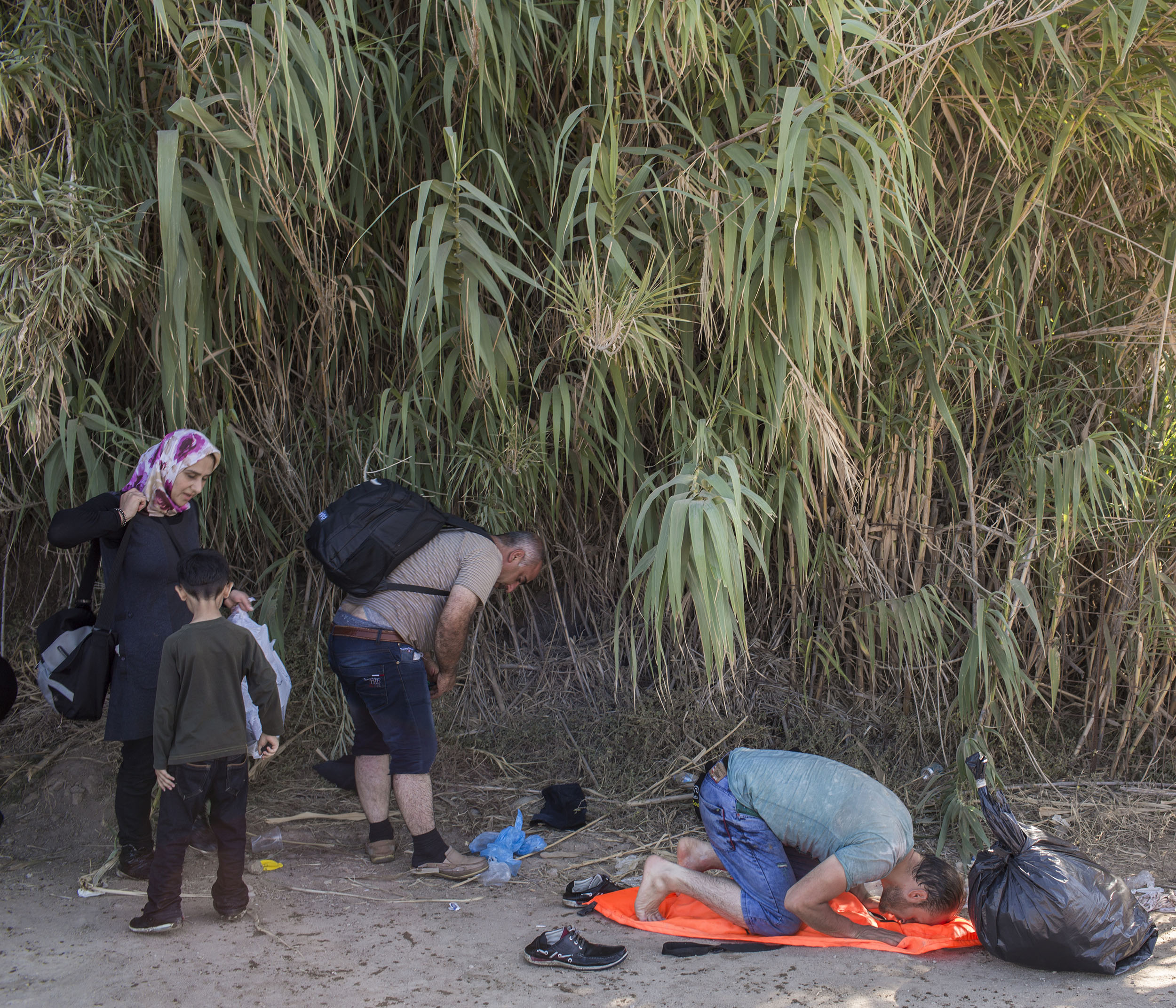 33-year-old Syrian refugee Ahmad from Aleppo prays immediately after landing on Greek shores on the island of Lesbos.
