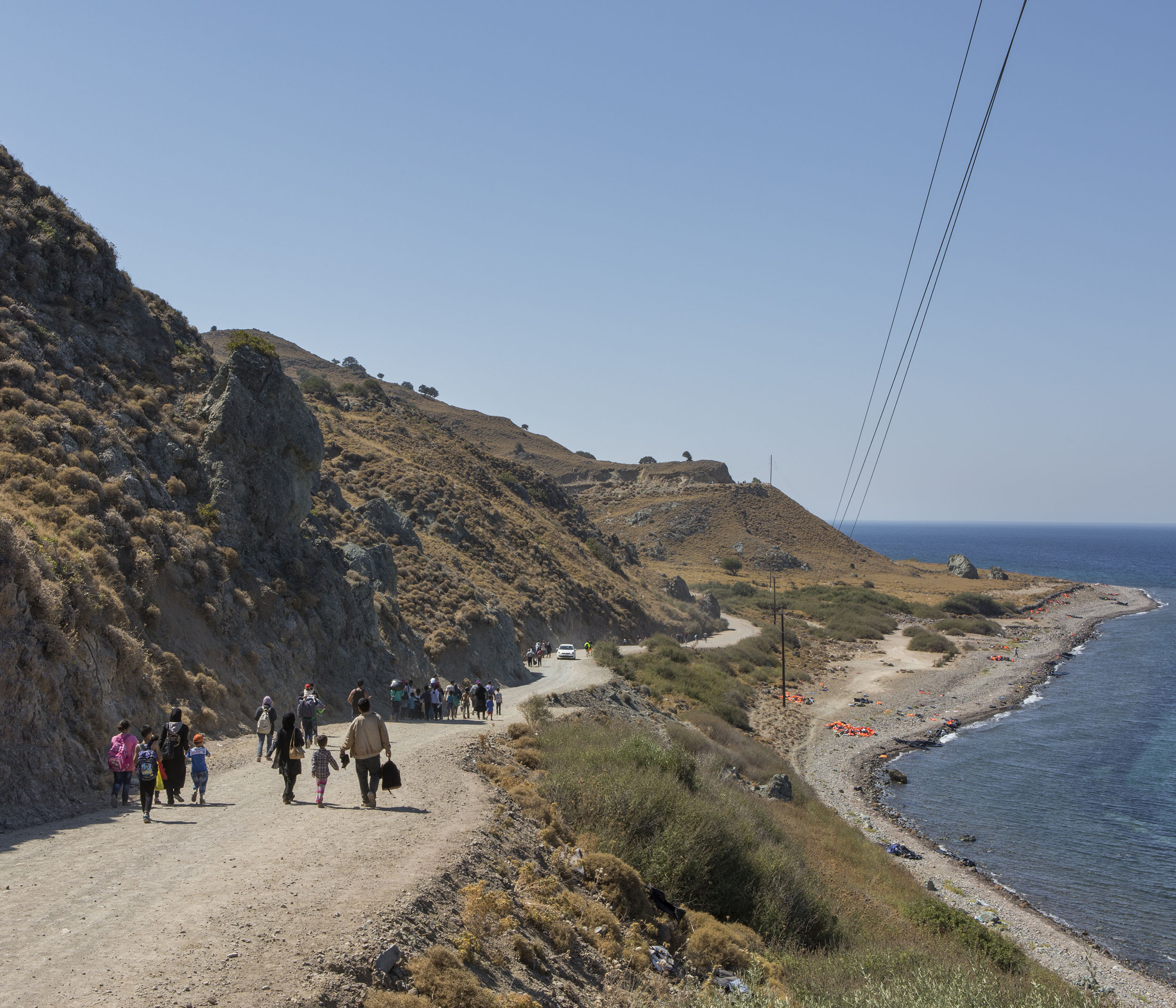 A mixed group of Syrian refugees and other migrants walk towards the nearest town after landing on the Greek island of Lesbos having crossed the Aegean from Turkey.