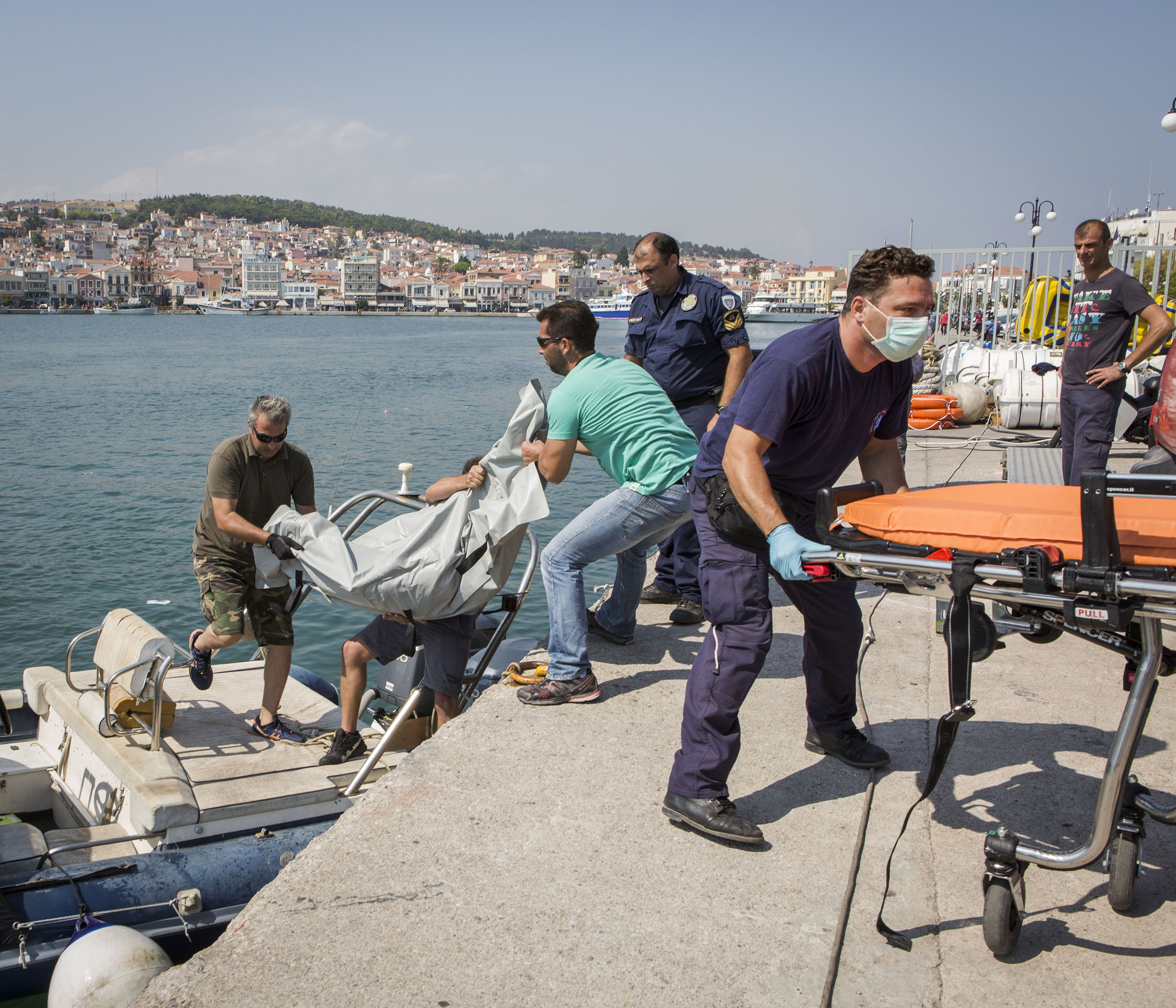 Greek coastguard officials and port police together with paramedics lift an unidentified body believed to be a migrant from a boat which had sunk near the Eastern coast of Lesbos earlier that morning. The boat, which had been travelling from Turkey