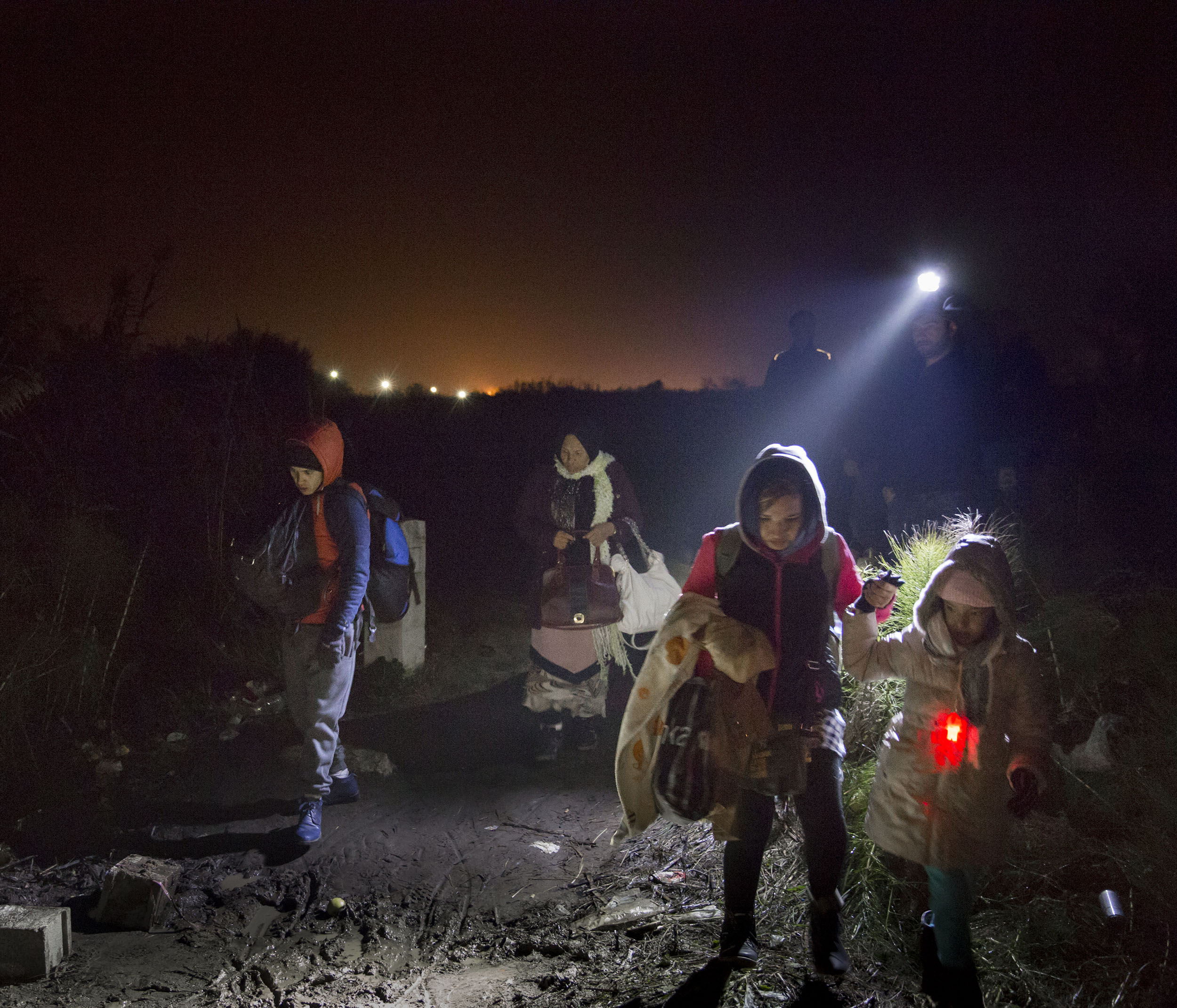 A group of Syrian refugees cross the border from Macedonia into Serbia under the cover of darkness. A local group of Macedonian volunteers, many of them Muslims themselves, helped guide the refugees with strong torches towards the informal crossing.