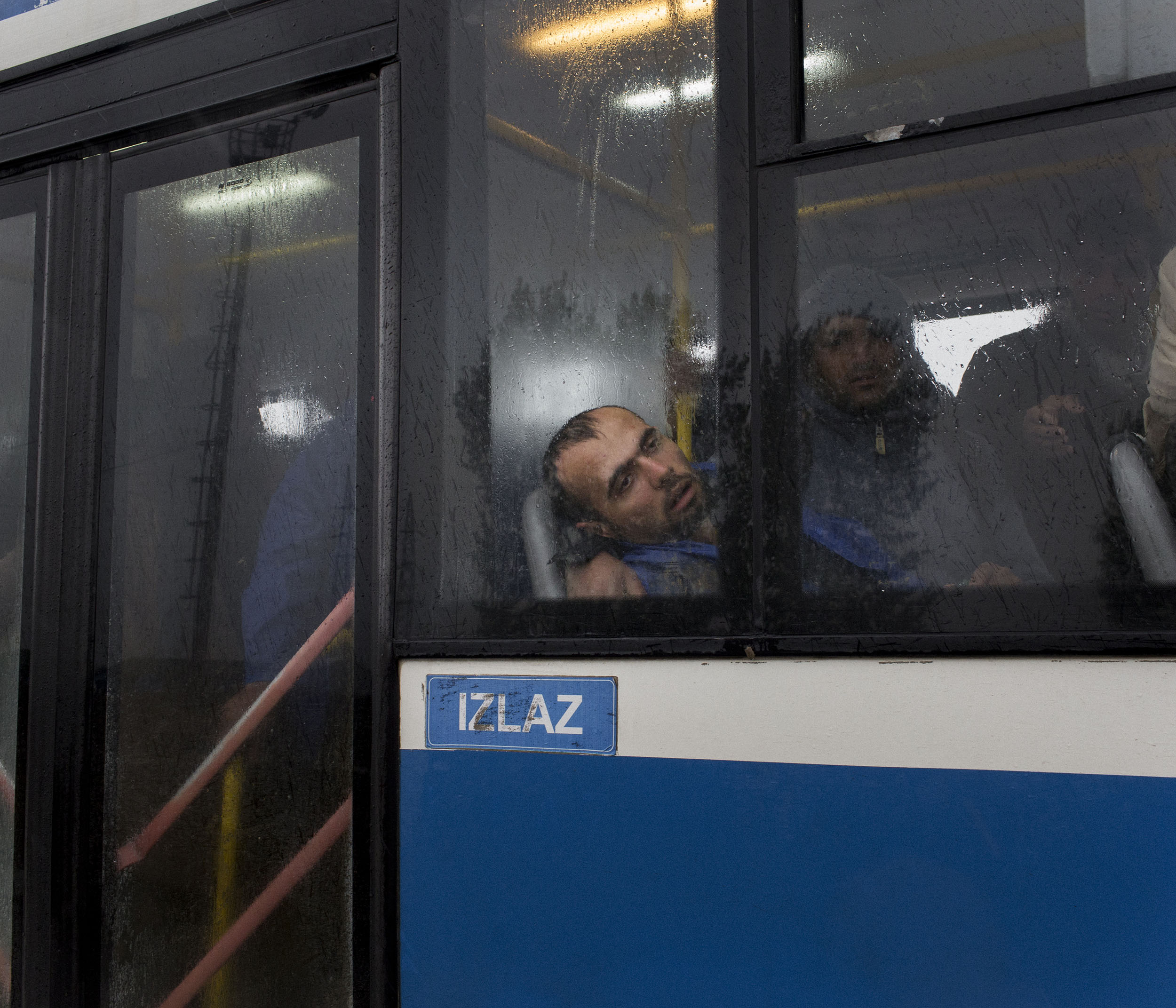 A Syrian refugee who was sick after waiting throughout the night to cross the border from Serbia into Croatia waits to be taken off a bus after arriving at the Babska processing centre in Croatia.