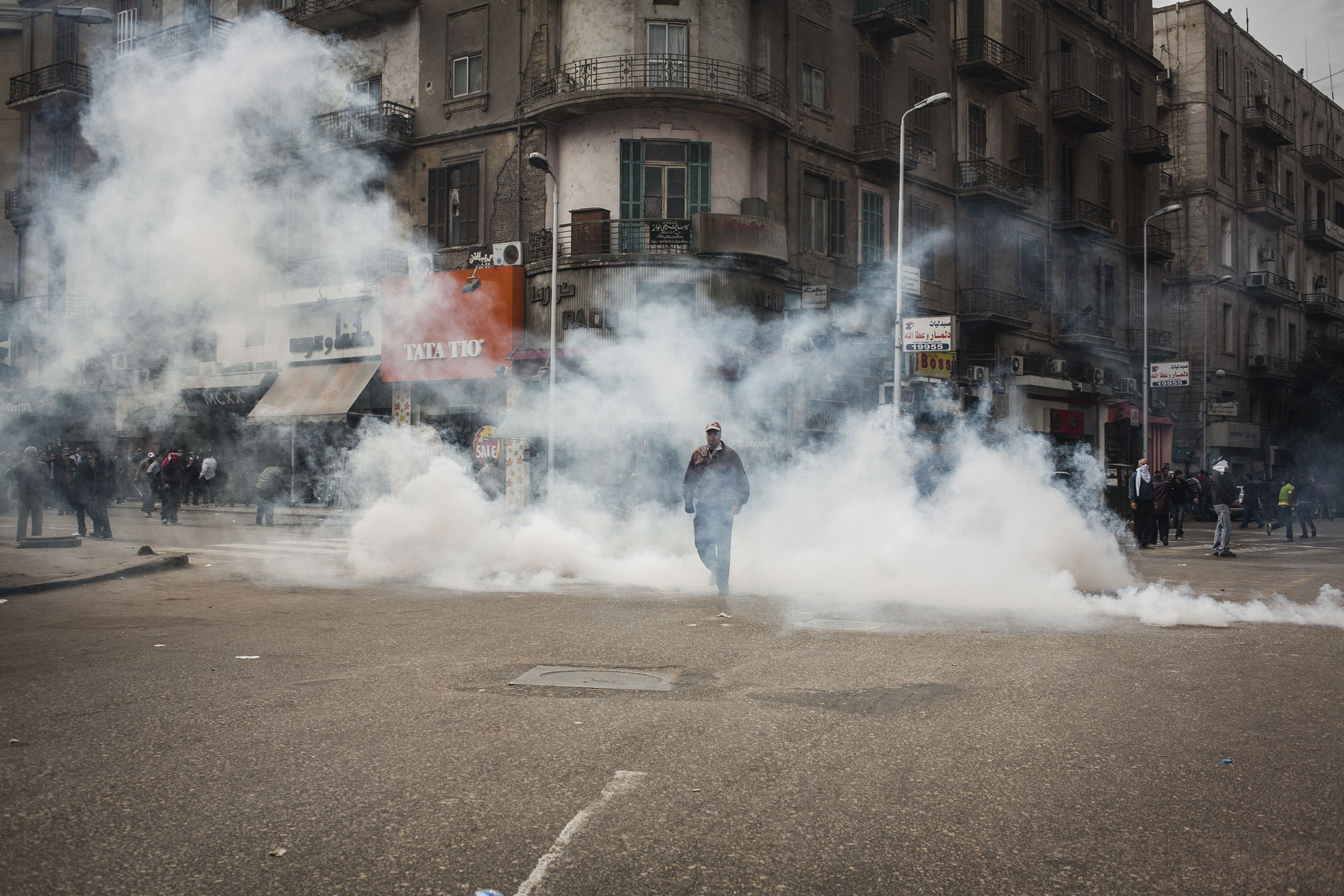  Protesters march through the streets of central Cairo amidst tear gas fired by the police. 25 January 2011 saw the beginning of a non-violent 18 day protest movement that eventually ended the 30-year rule of Hosni Mubarak and his National Democratic