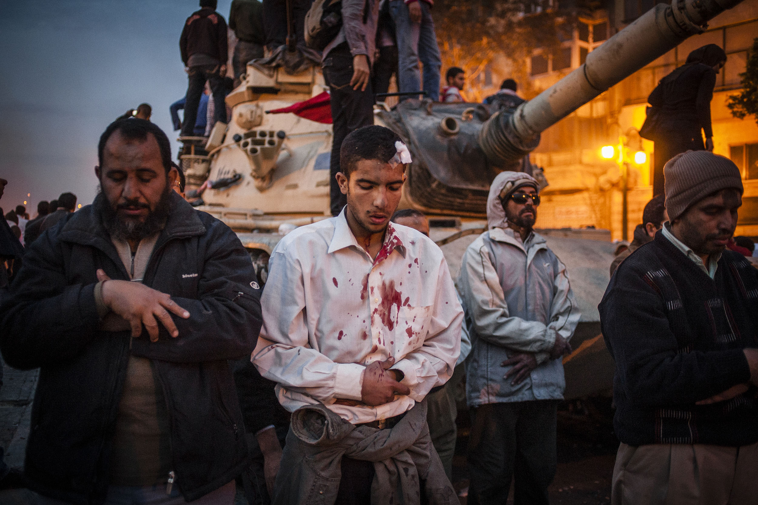  Anti-government protesters answer the evening call to prayer in front of an abandoned army tank amidst violent clashes with pro-Mubarak supporters outside the Egyptian Museum in Tahrir Square.  
