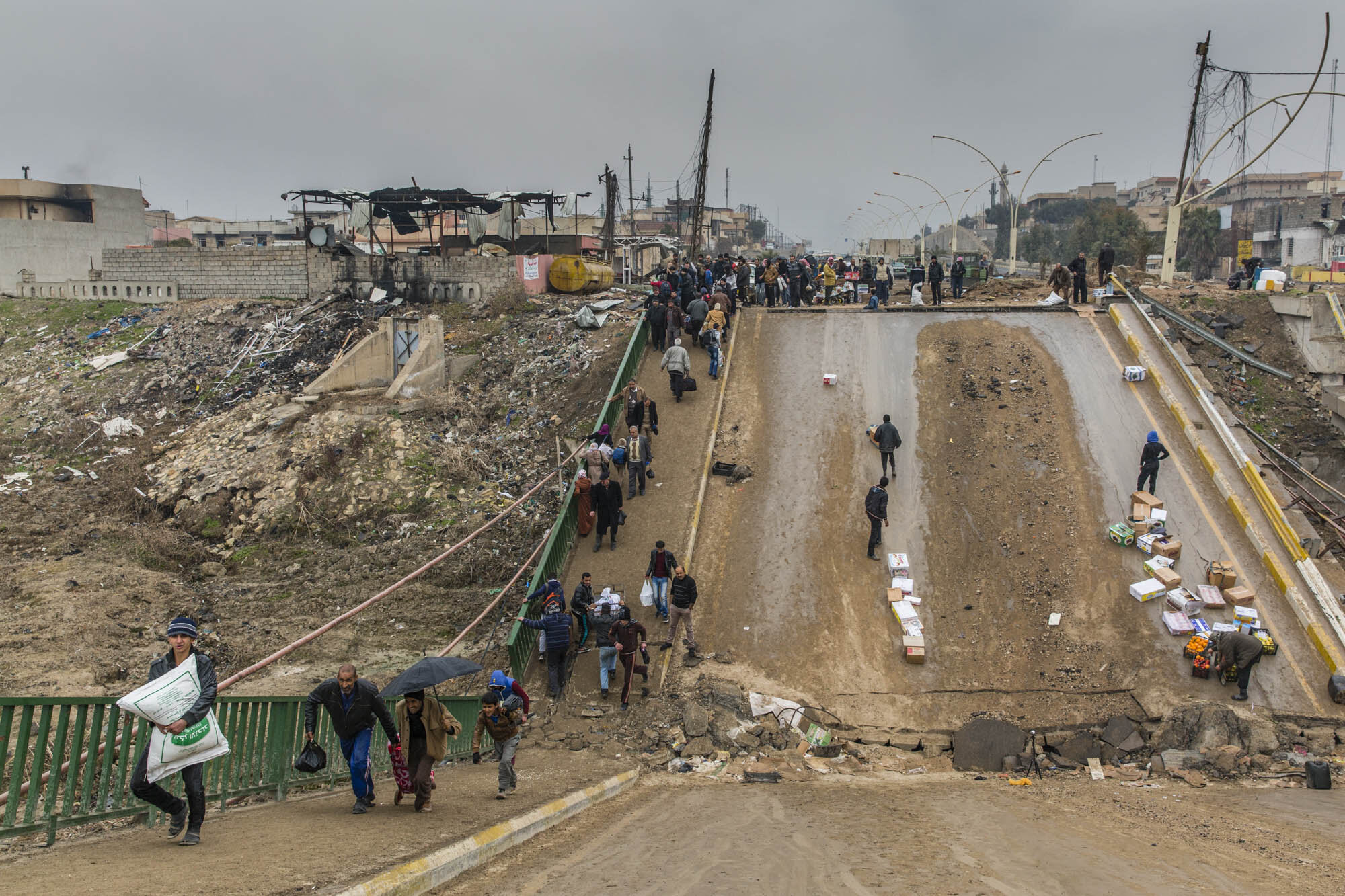  Some people fled the recently liberated Sukar neighbourhood, while others return having crossed a destroyed bridge that connects the area to the rest of the east Mosul. Iraq - January 2017 