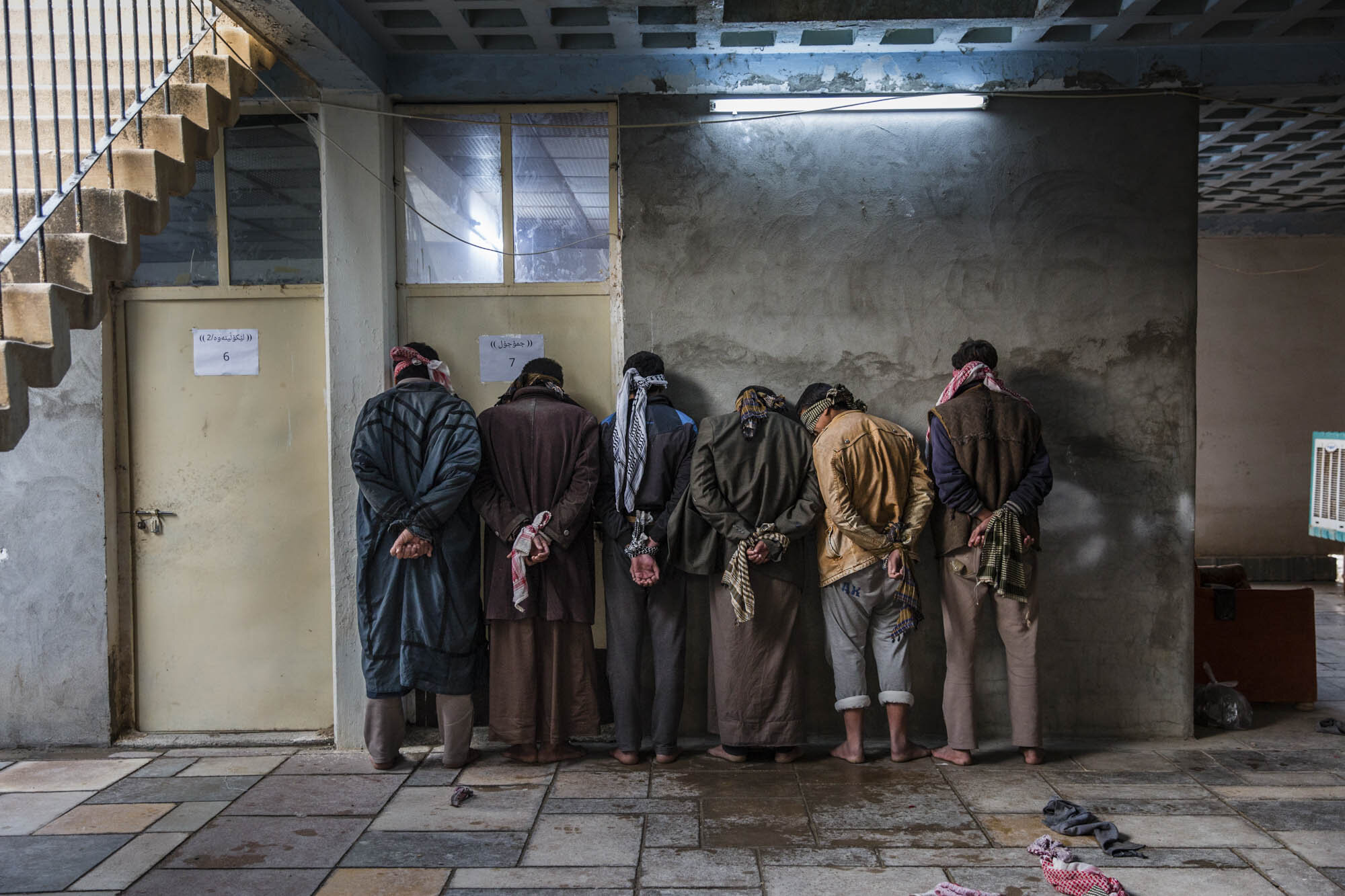  Iraqi men who had fled ISIS controlled areas in Hawija, waited to be questioned about possible links to the terror group by Kurdish security personnel at a base near Kirkuk. Iraq - December 2016 