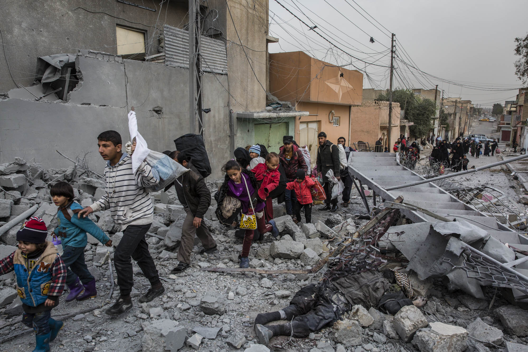  Civilians fleeing heavy clashes between Iraqi special forces and ISIS militants in the Jadidah neighbourhood of west Mosul walked past the body of an ISIS fighter killed in a airstrike the night before. Iraq - March 2017 