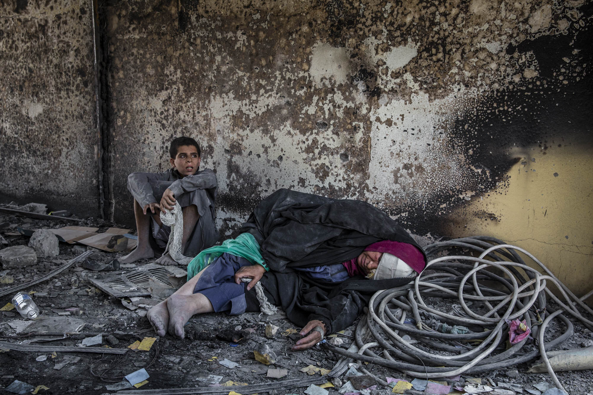  A woman and young boy collapsed from fatigue after fleeing the last area of Mosul’s Old City still controlled by ISIS. Iraq - July 2017 