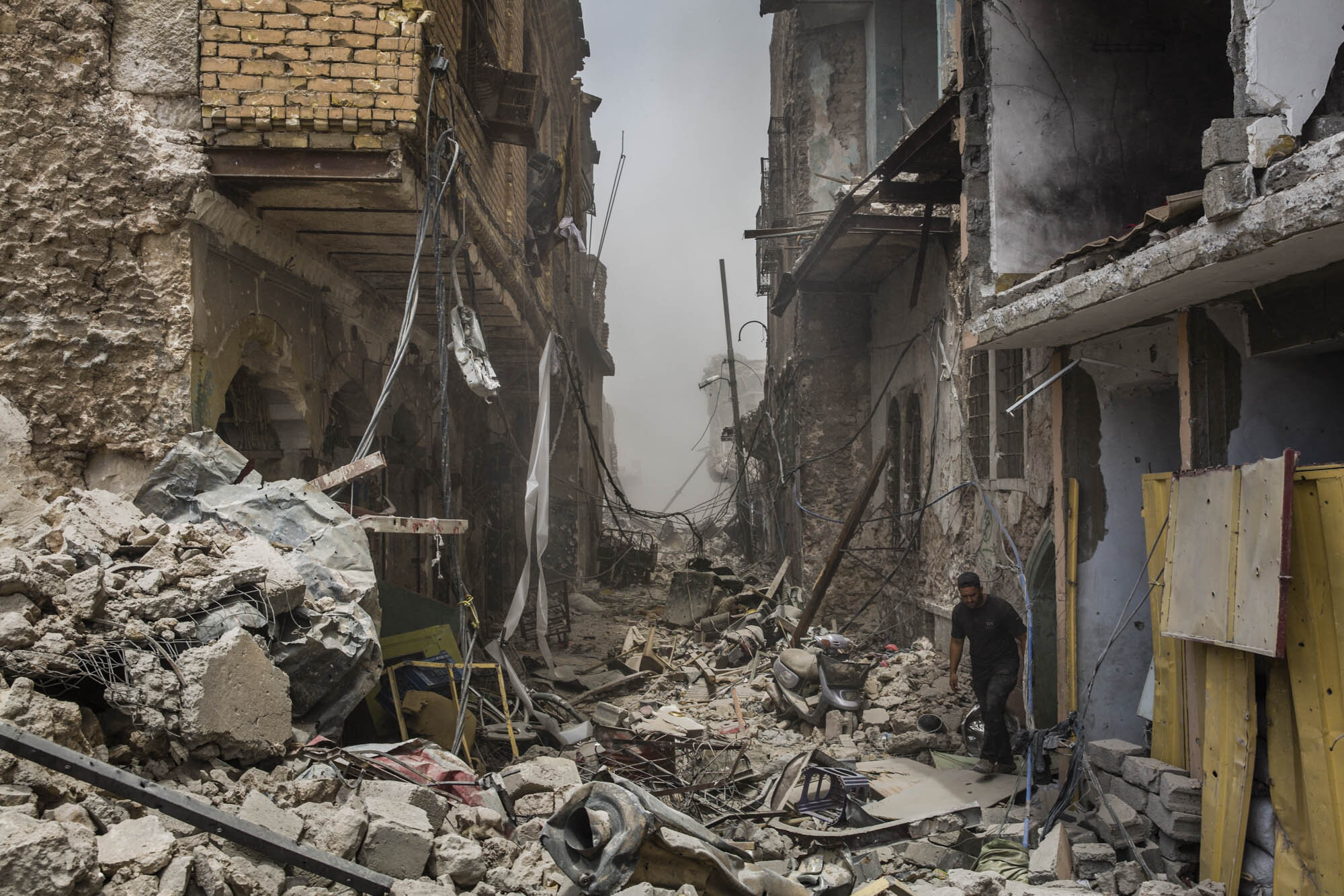  An Iraqi special forces soldier walked through a destroyed street in the Old City district of west Mosul, while smoke from an nearby airstrike settled in the background. Iraq - July 2017 