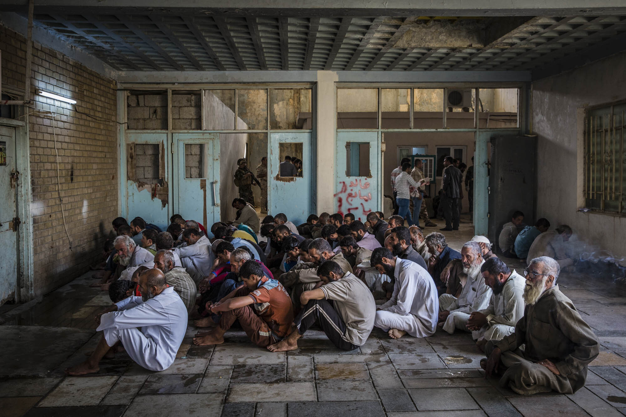  Displaced men waited to be questioned at a security screening centre near Kirkuk in Kurdish controlled Iraq after fleeing the last remaining ISIS held areas in the province of Hawija. Iraq - October 2017 