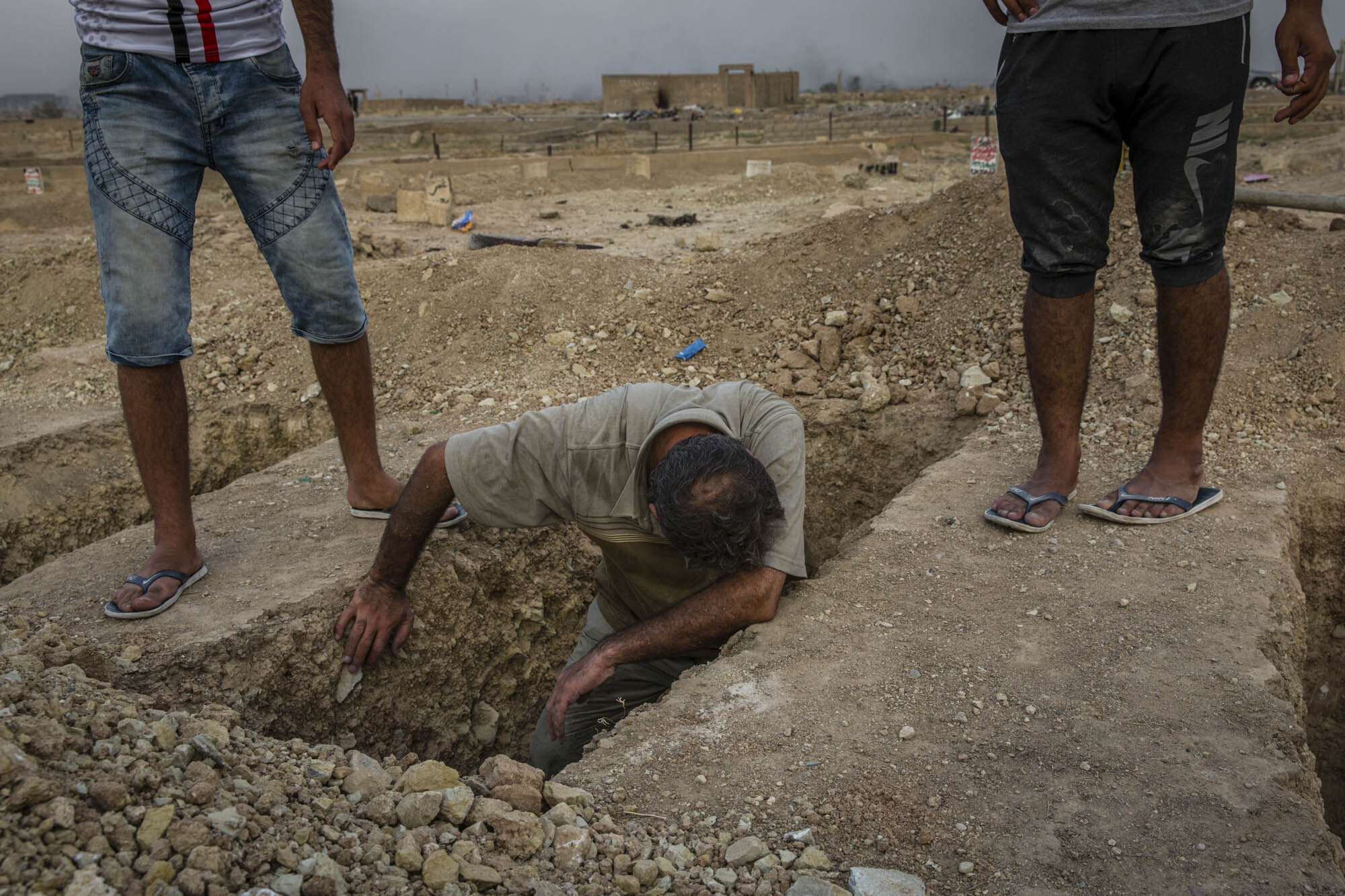  Fouad Mohammed Sadi wept as he helped to lower the bodies of his wife, daughter and two brothers into the ground. They were all killed in separate air and artillery strikes during the final stages of the fight for Mosul and their bodies had remained