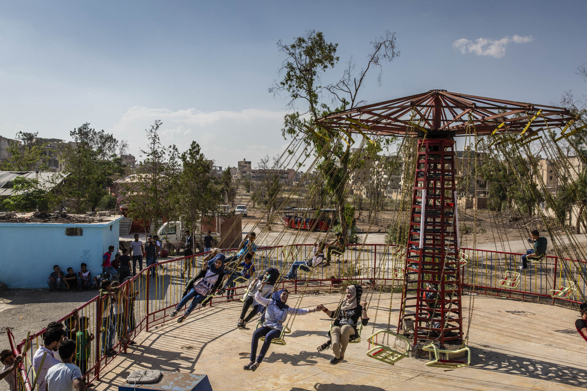  A group of teenage girls enjoyed a chair ride at a small amusement park in Raqqa on the first day of the Muslim holiday of Eid. Syria - June 2018 