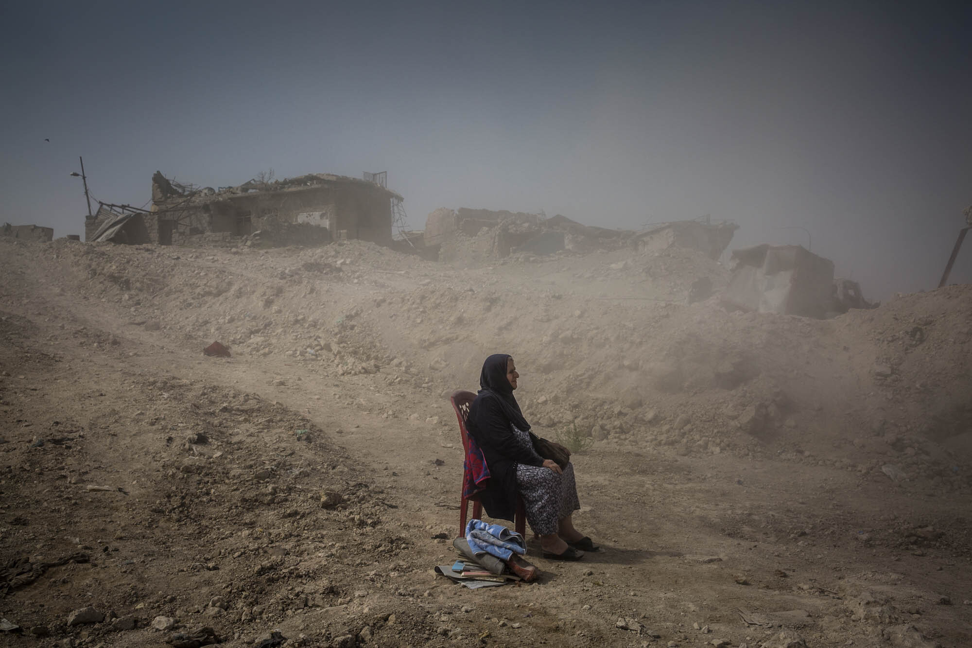  Nadhira Rasoul looked on as Iraqi Civil Defence workers dug out the bodies of her sister and niece from her house in the Old City of Mosul, where they were killed by an airstrike in June 2017. Iraq - September 2017 