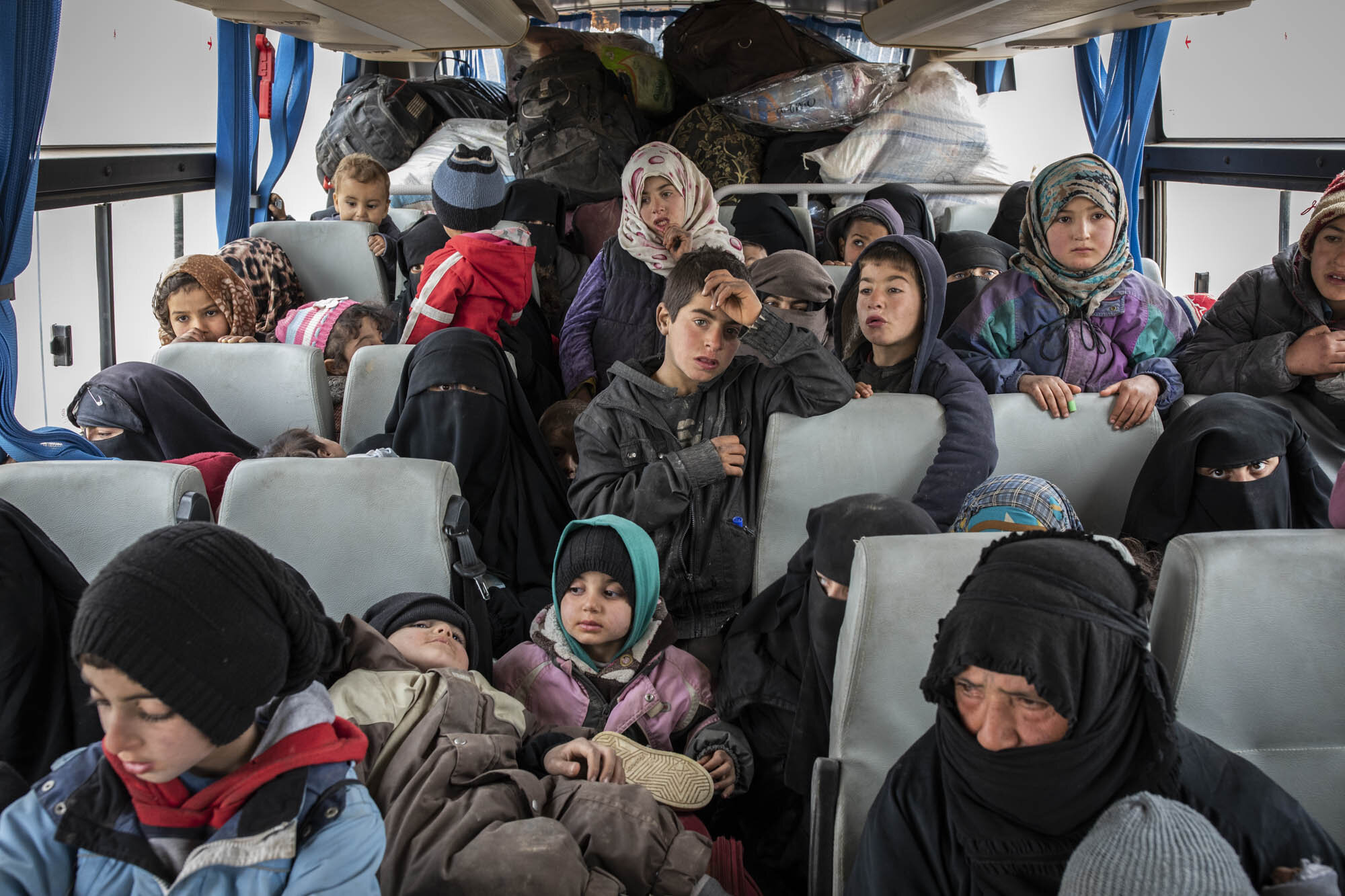  A group of shell shocked women and children, suspected of being the wives and family members of ISIS militants, who had fled the last area of ISIS control around the village of Baghuz, were crammed onto buses by Kurdish security forces at a screenin