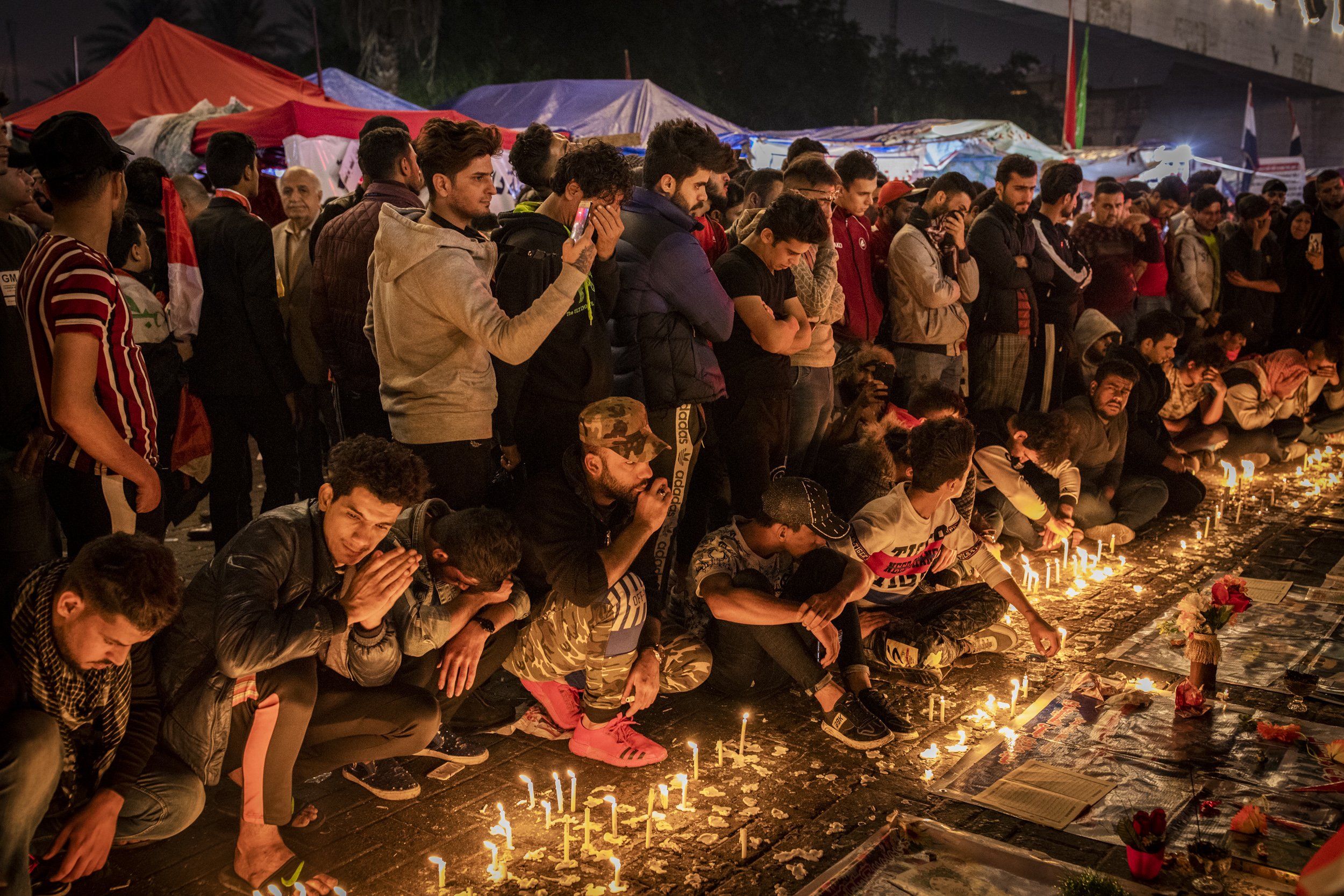 Mourners lit candles and prayed for a young man who had been killed by Iraqi security forces during clashes in Baghdad yesterday. Tahrir Square, Baghdad.