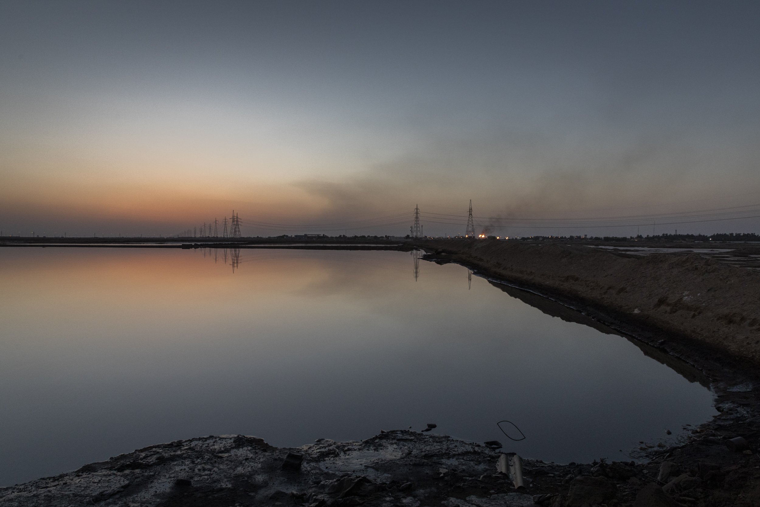  A tailing pond full of oily water that is by-product of oil exploration, sits less than a few kilometres from the village village Nahran Bin Omran,  a heavily polluted area 15km north of Basra city. 