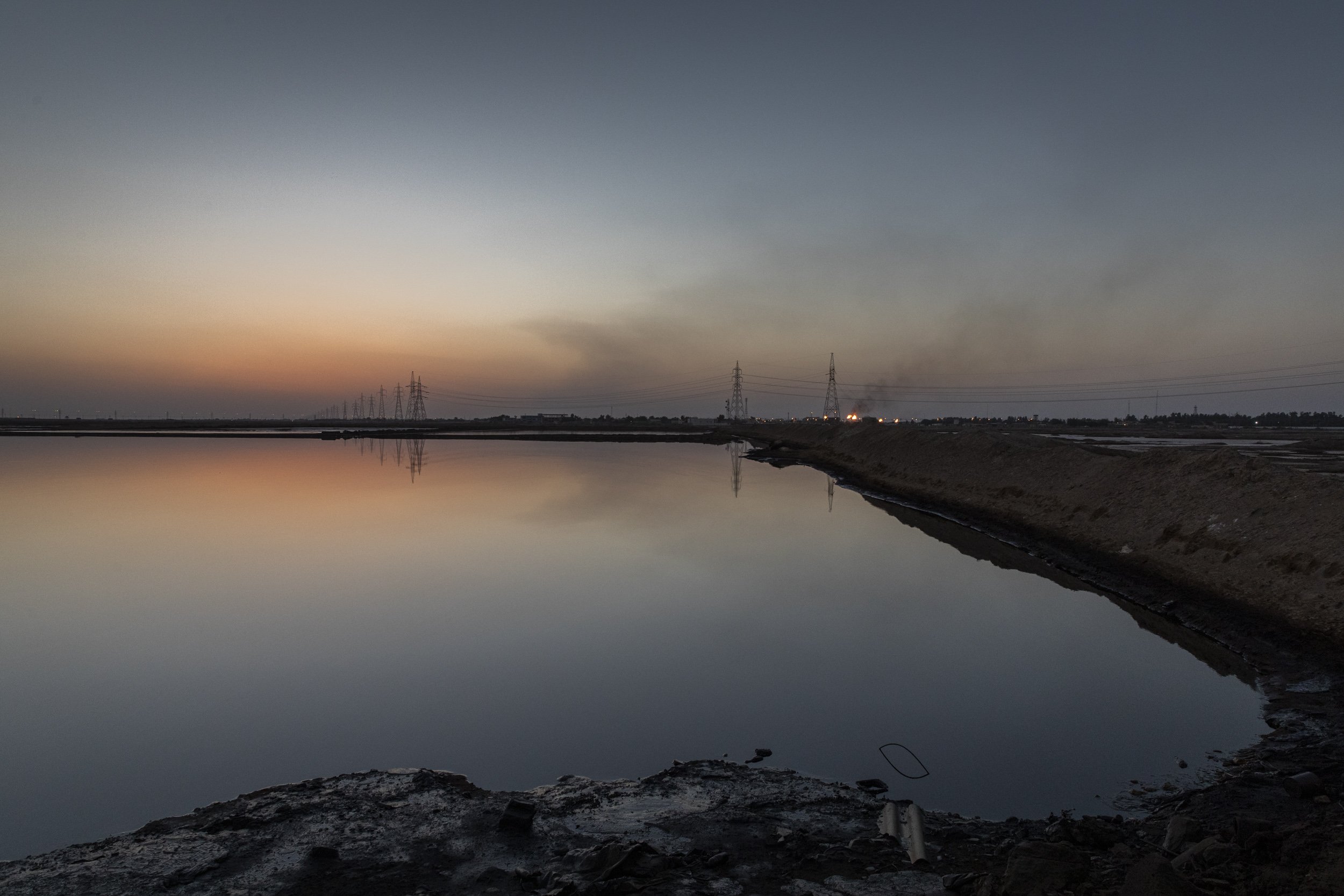 A tailing pond full of oily water that is by-product of oil exploration, sits less than a few kilometres from the village village Nahran Bin Omran, a heavily polluted area 15km north of Basra city.