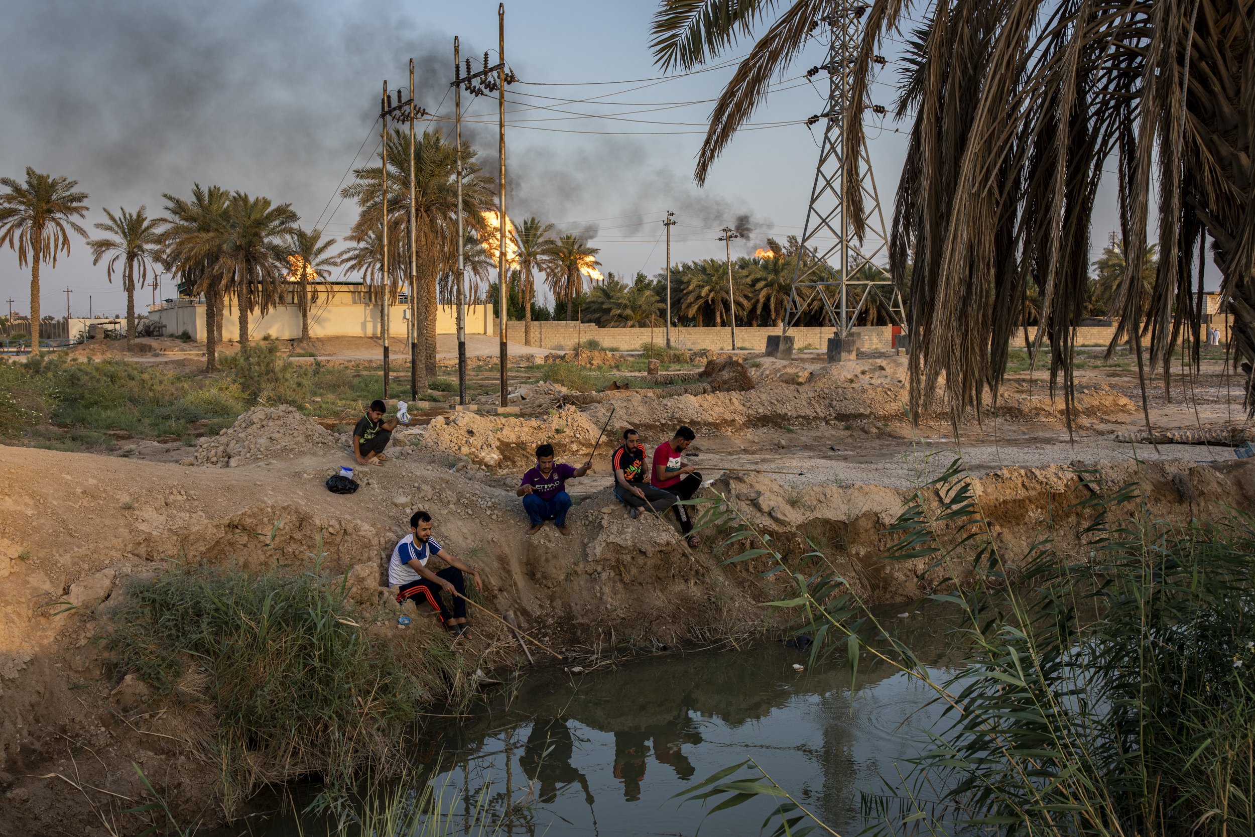  Men fished in a small stream coming off the heavily polluted Shatt al-Arab river in front of the Nahr Bin Omar Oil refinery,15km north of Basra city. 