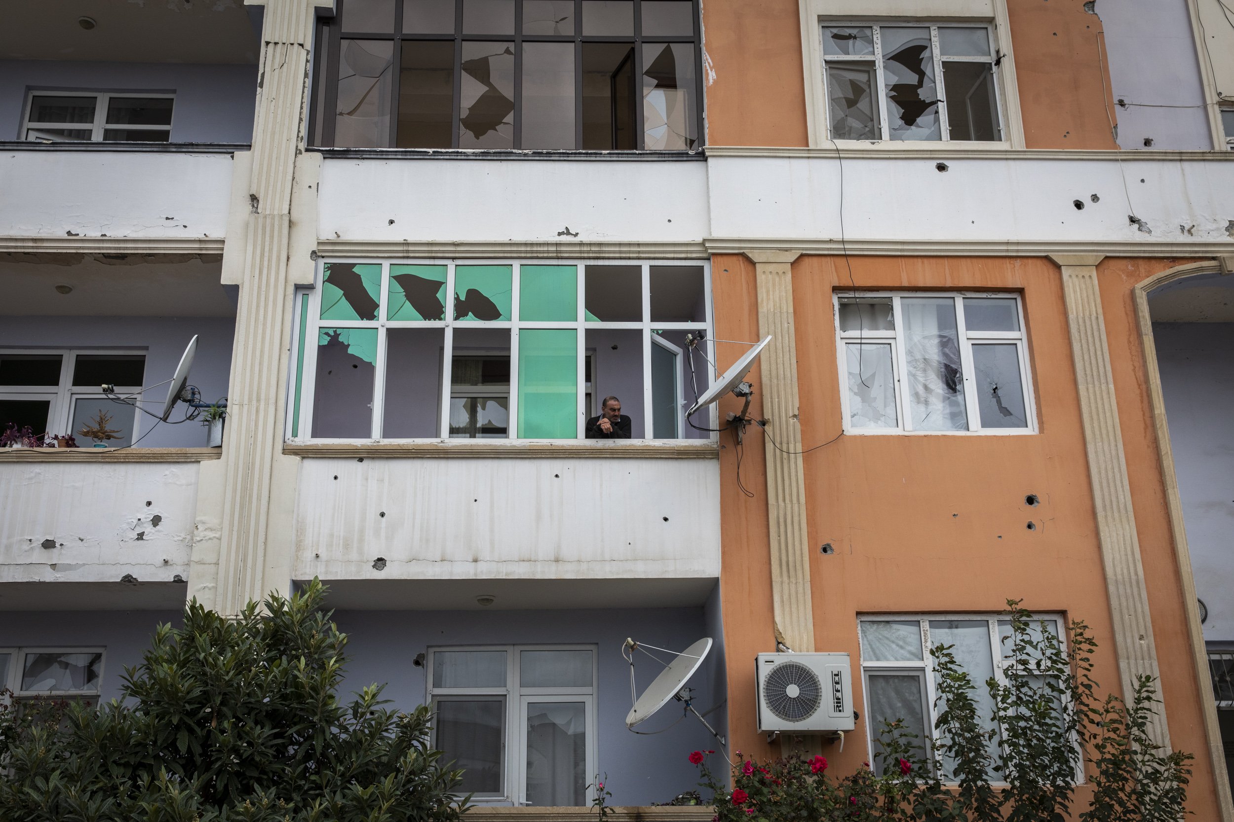 A man peered out from the broken window of his apartment in the city of Terter, which is just a few kilometres from the frontline and has been routinely bombarded since the start of the latest war between Azerbaijan and Armenia.