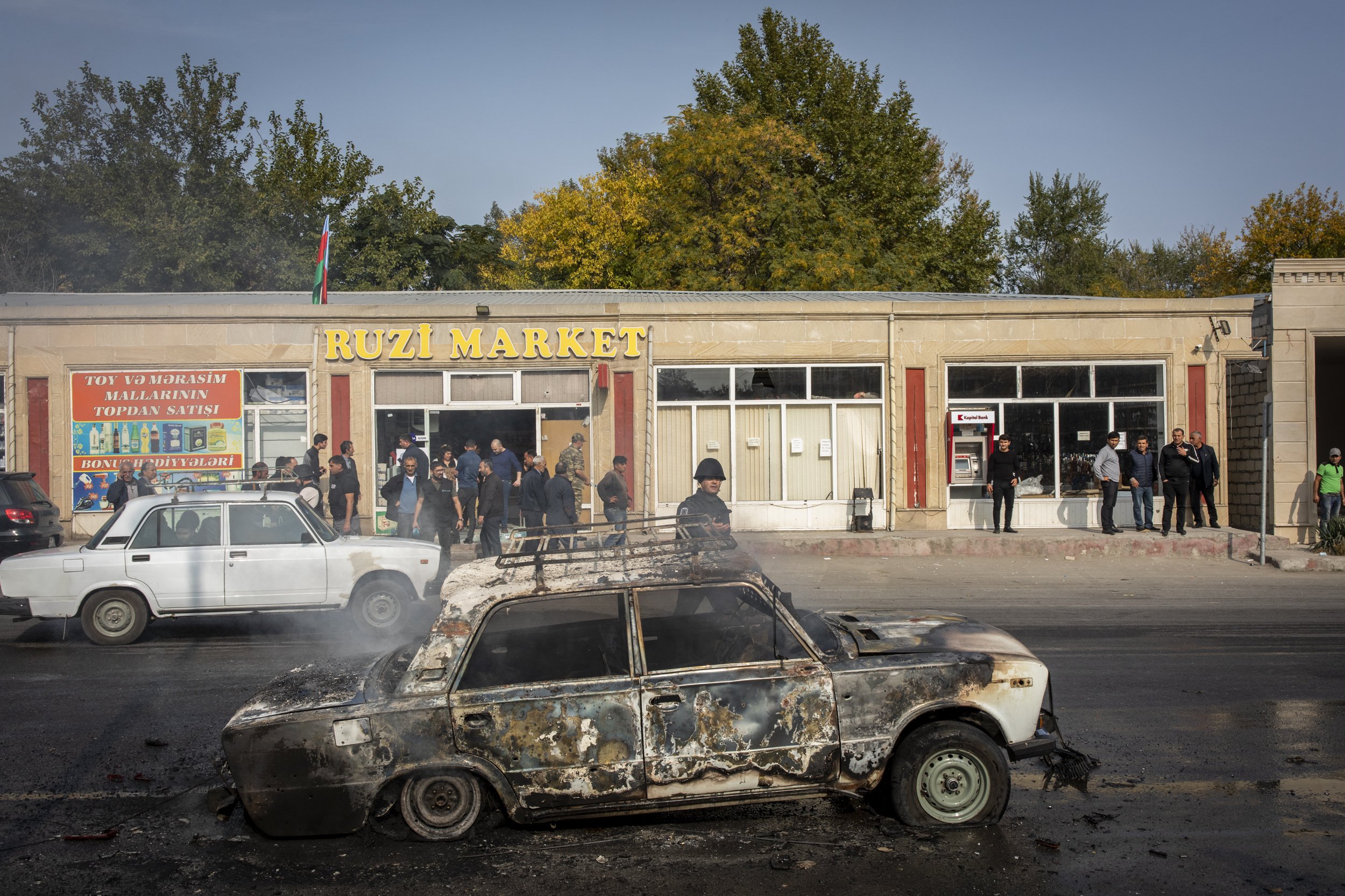  The smouldering wreck of a car sat in the road moments after a rocket attack launched by Armenian forces on the city of Barda in Azerbaijan. 