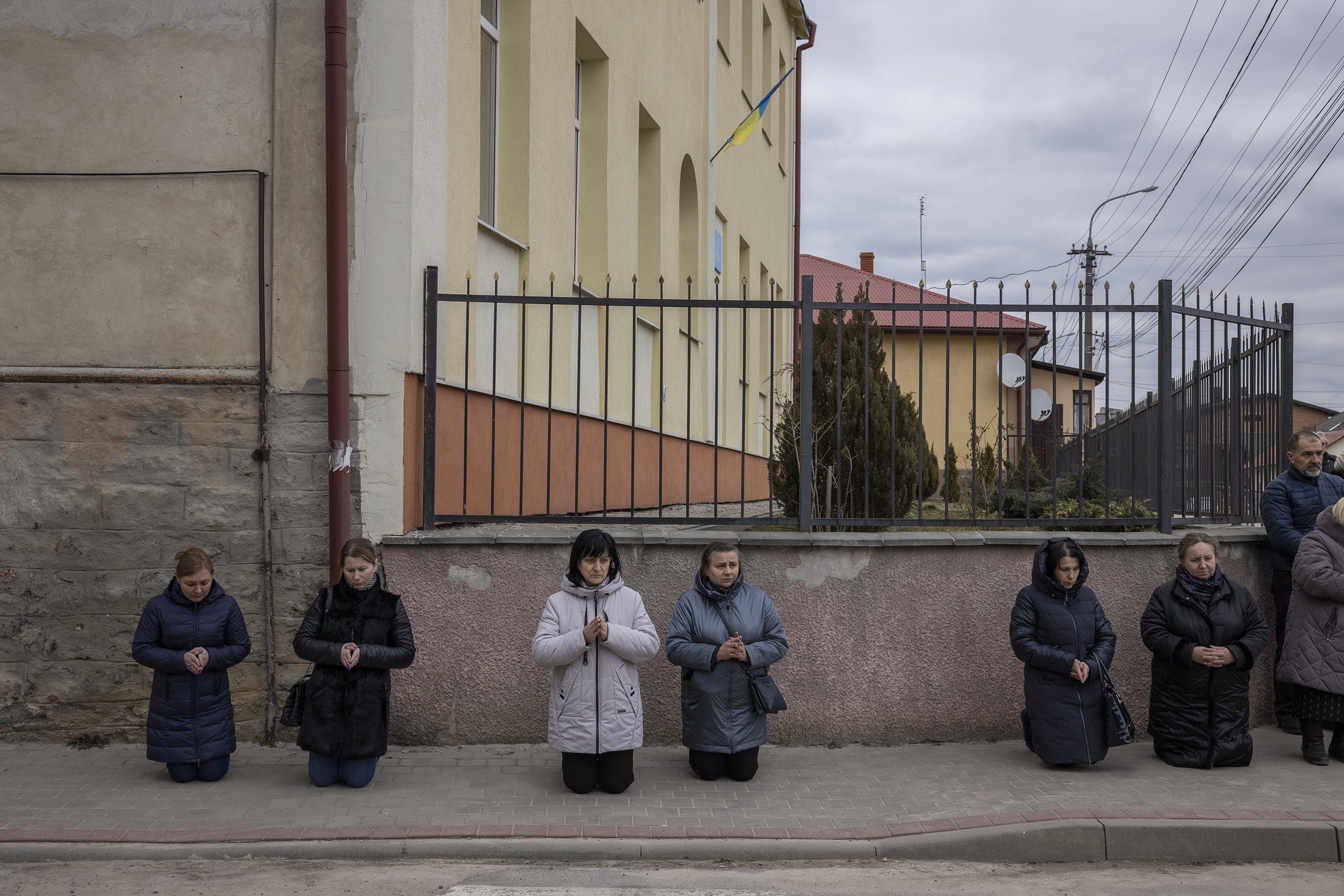  Locals came out of their houses or stopped on the street to pay their respects as a funeral procession for a Ukrainian soldier passed through the town of Yavoriv in western Ukraine. March, 2022. 