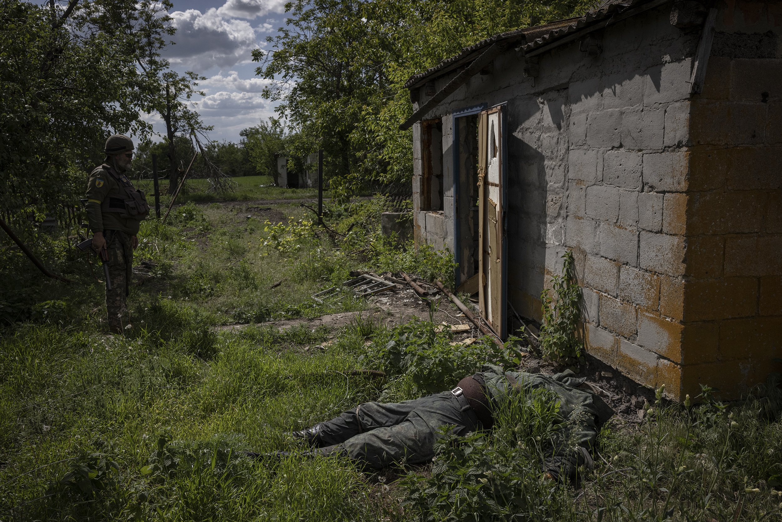  The body of a Russian soldier lay in the garden of a house in the recaptured village of Novopil, which local volunteer fighters had won back several days before. May, 2022. 