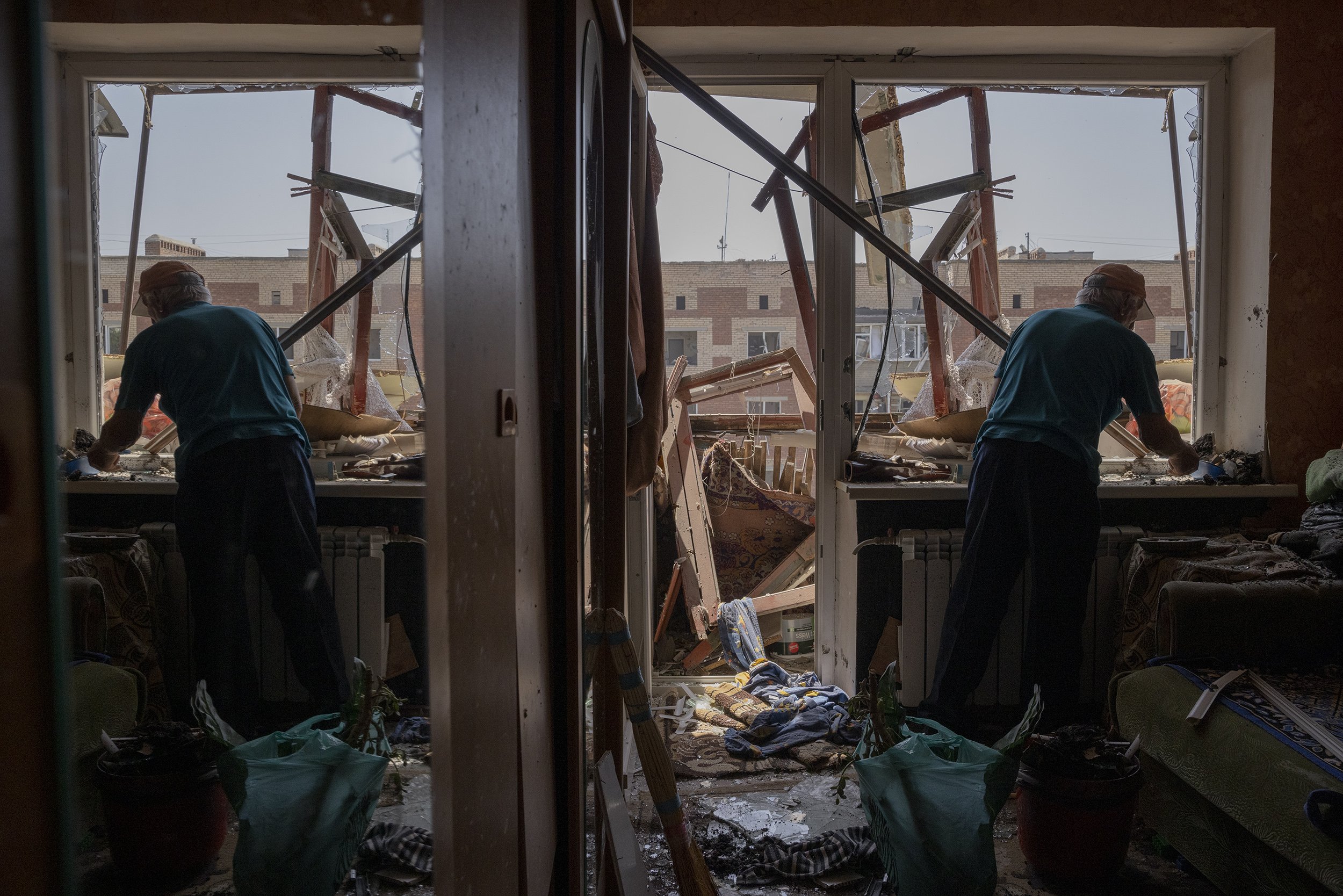  Mykola Telegin cleared up debris in his daughters apartment after a Russian strike hit a residential area in Sloviansk. 3 people were said to have been killed in the attack, with another 6 injured. May, 2022. 