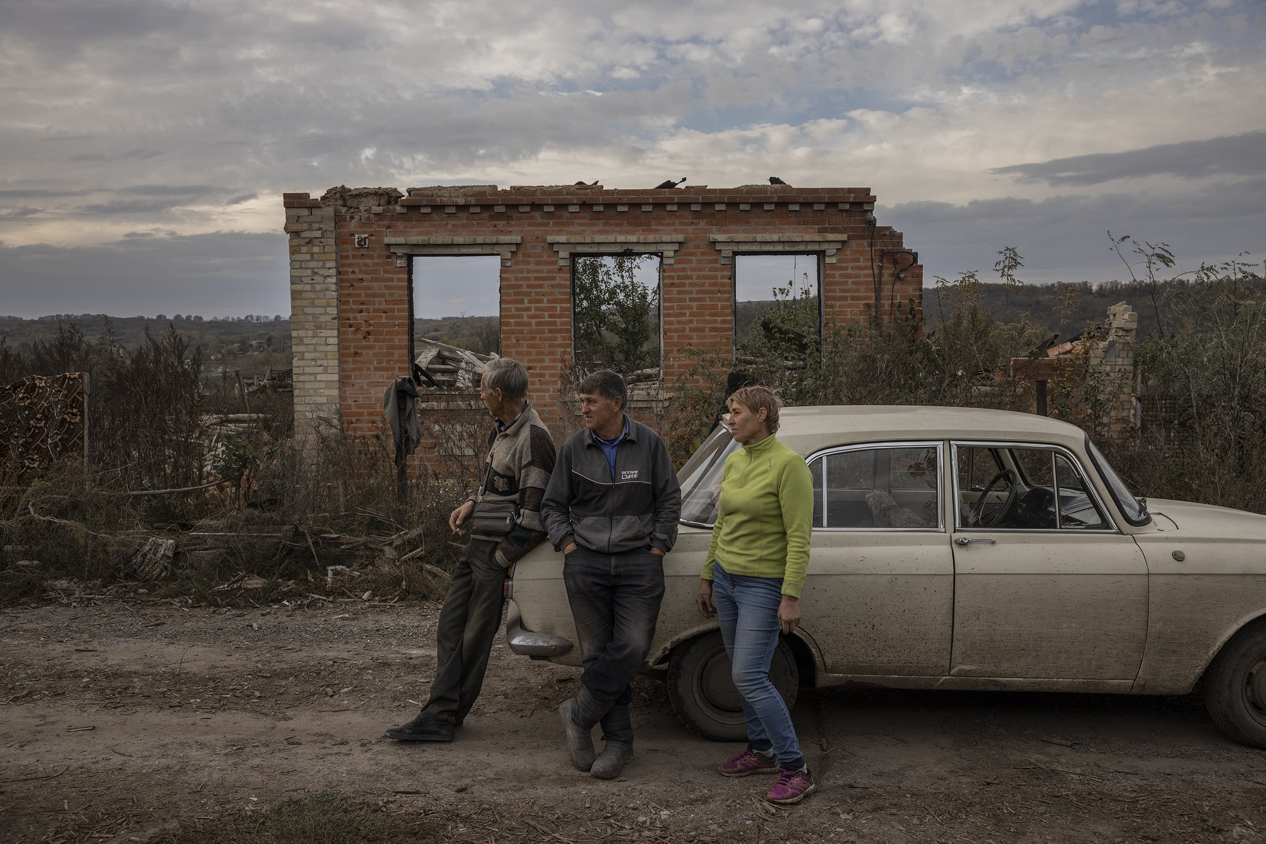  Serhii and his wife Iryna chatted with a neighbour, one of only a handful of people who were still living in the heavily destroyed village of Kamyanka. October, 2022. 