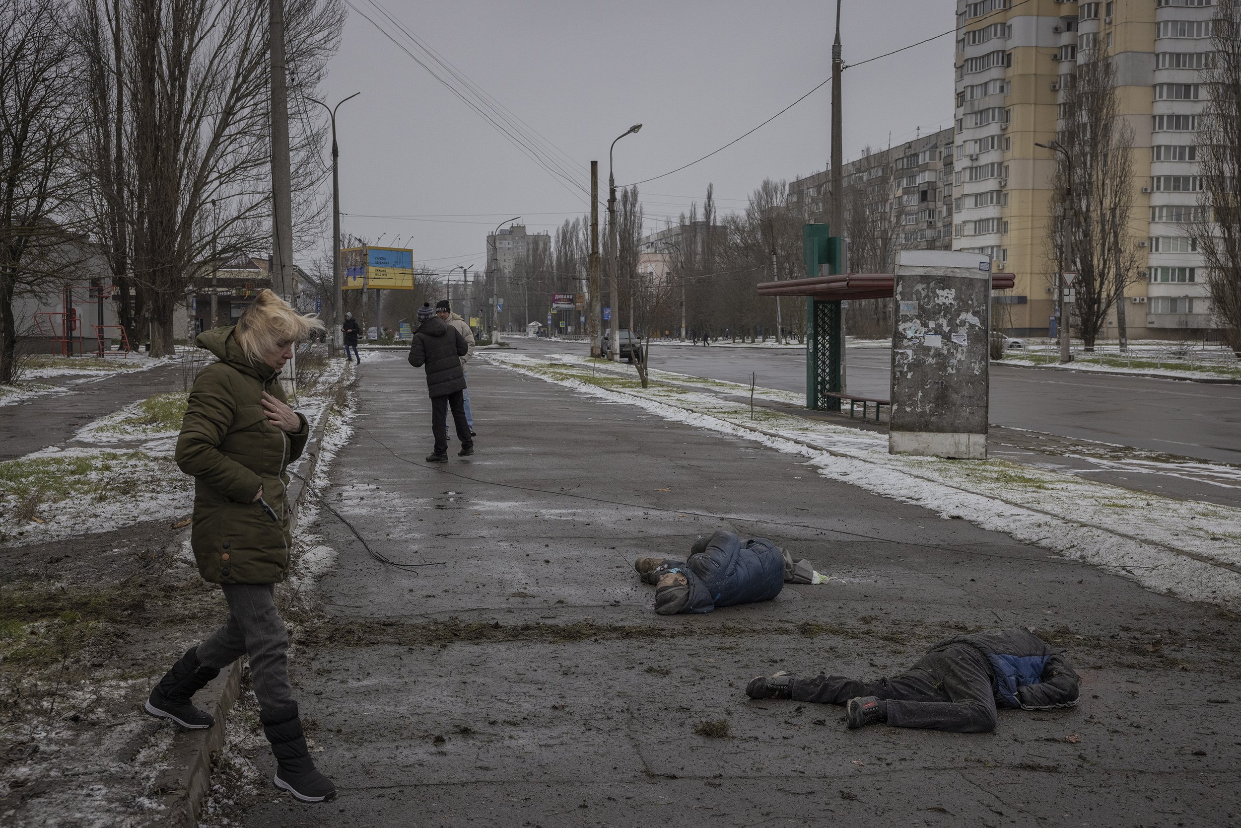  The bodies of a two men lay on the sidewalk shortly after they were killed in a Russian artillery strike that landed in a residential neighbourhood of Kherson city. February, 2022. 