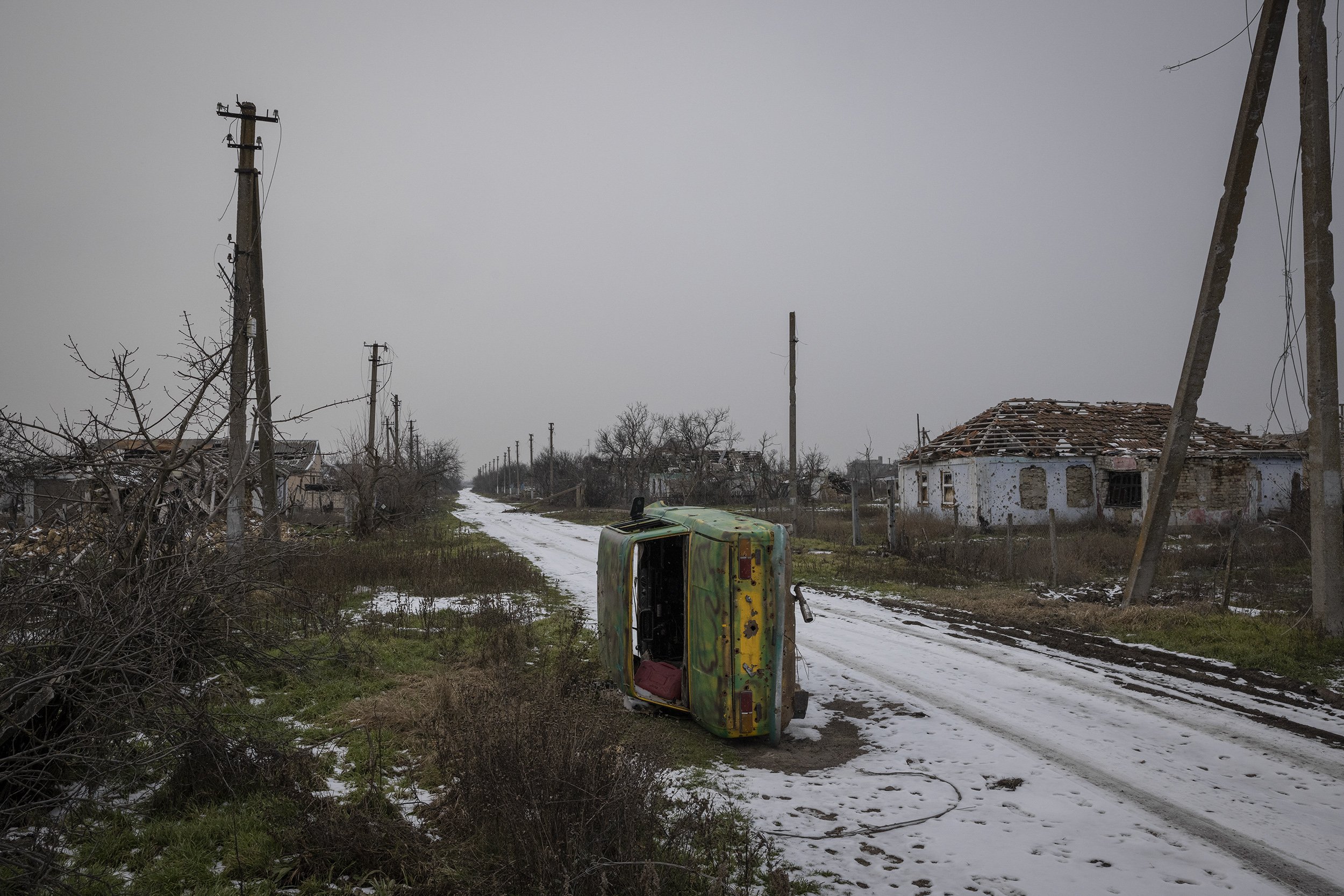  An overturned military car lay on side of the road in the heavily destroyed village of Posad-Pokrovske near Kherson. February, 2022. 