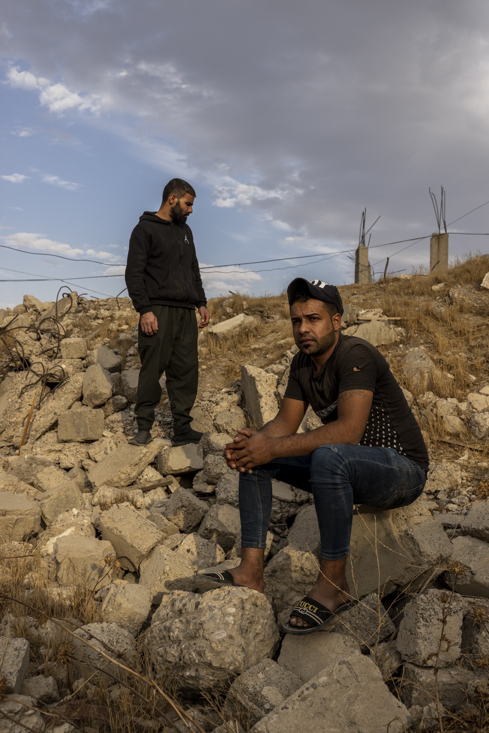  Abdul Aziz Ahmed Araj, right, and his brother Saddam amid the ruins of the warehouse where their brother and other family members were killed in the Yabisat neighbourhood of West Mosul.  