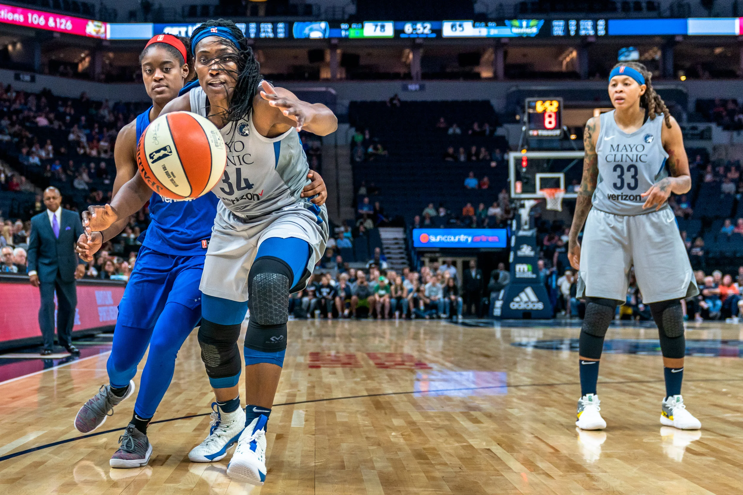 Sylvia Fowles saves a ball from going out of bounds as she's guarded by Kaela Davis in the Minnesota Lynx vs Dallas Wings game at Target Center.