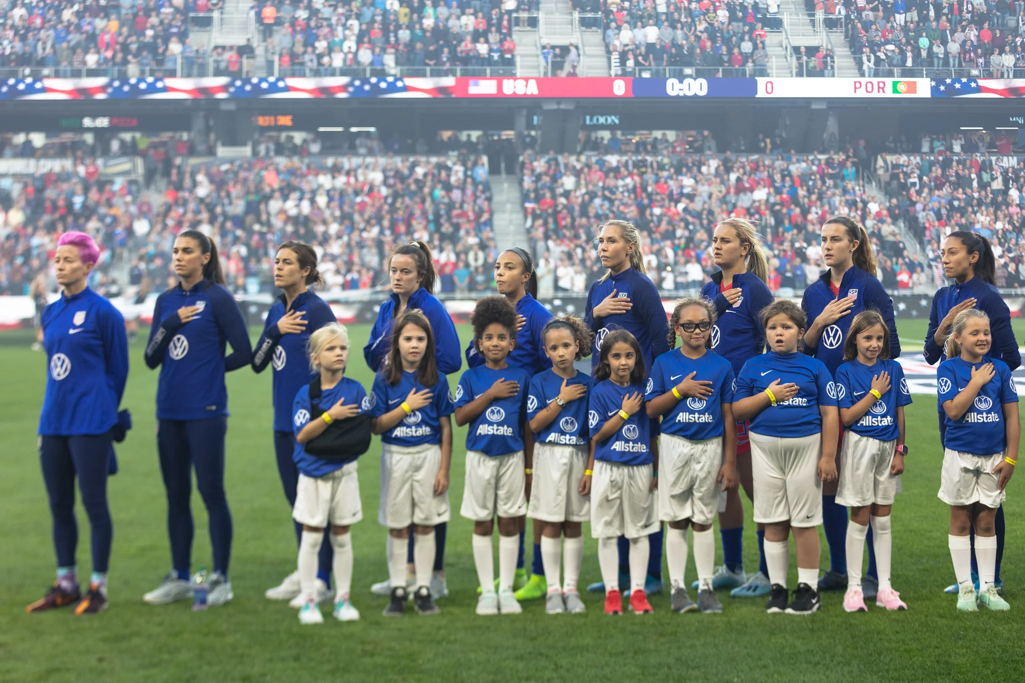 Team USA stands for the National Anthem before the match with young soccer players