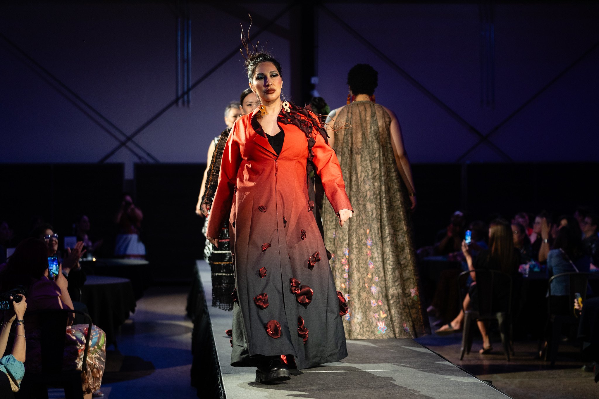 A model wearing a piece by The Restorative Apparel Co-Design Collection on the runway at Native Nations Fashion Night in Minneapolis