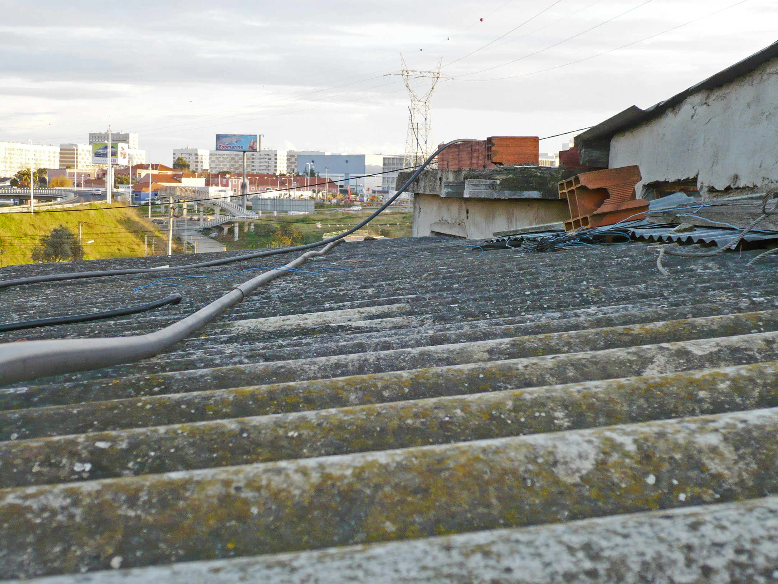 The use of different roofing materials in different periods: fibre cement boards (foreground) and concrete slab (back, beneath four red bricks).