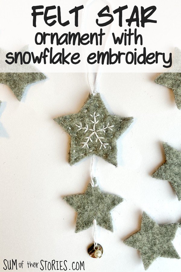 A grey felt star decoration with a simple embroidered snowflake design